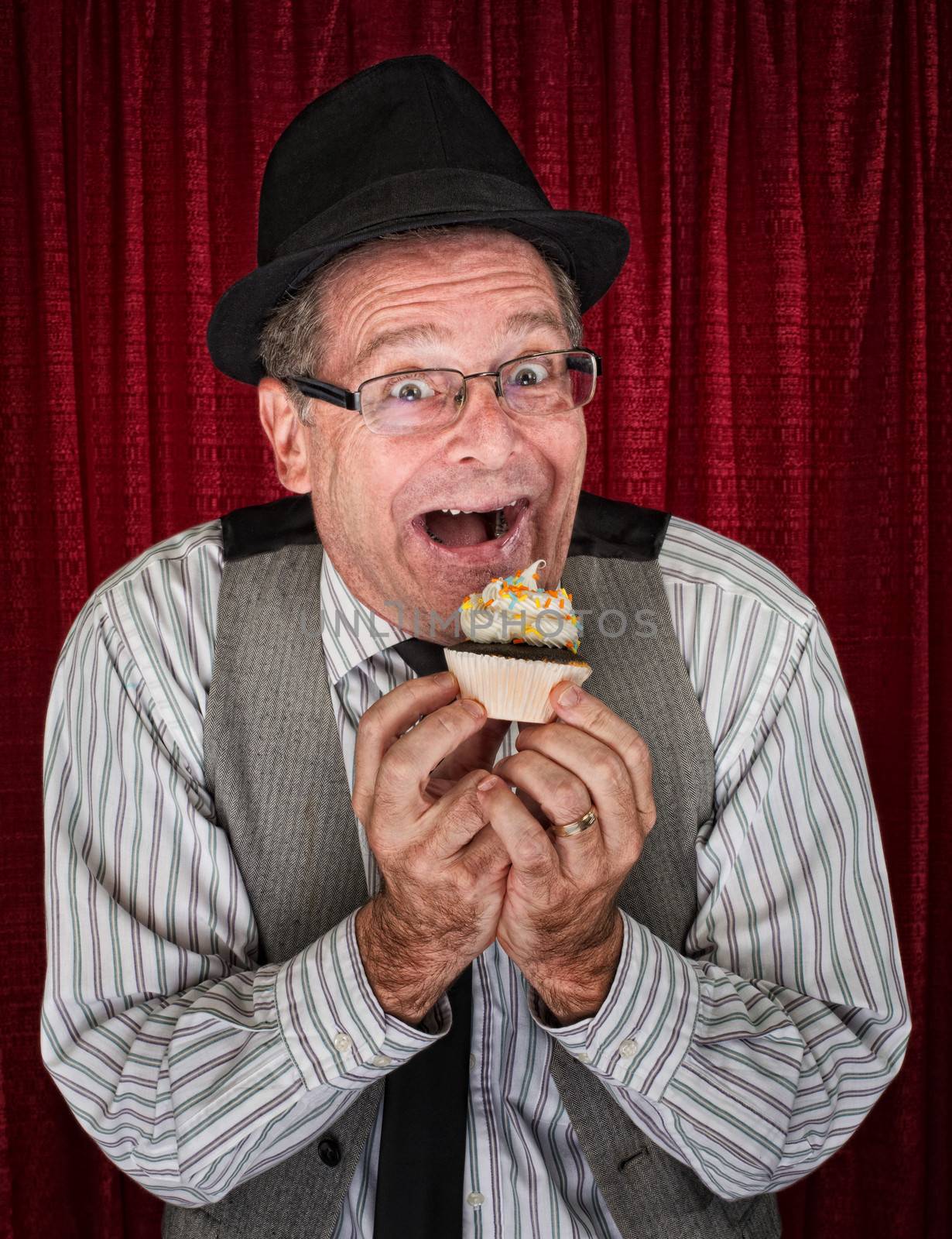 Happy retro style man holding a cupcake