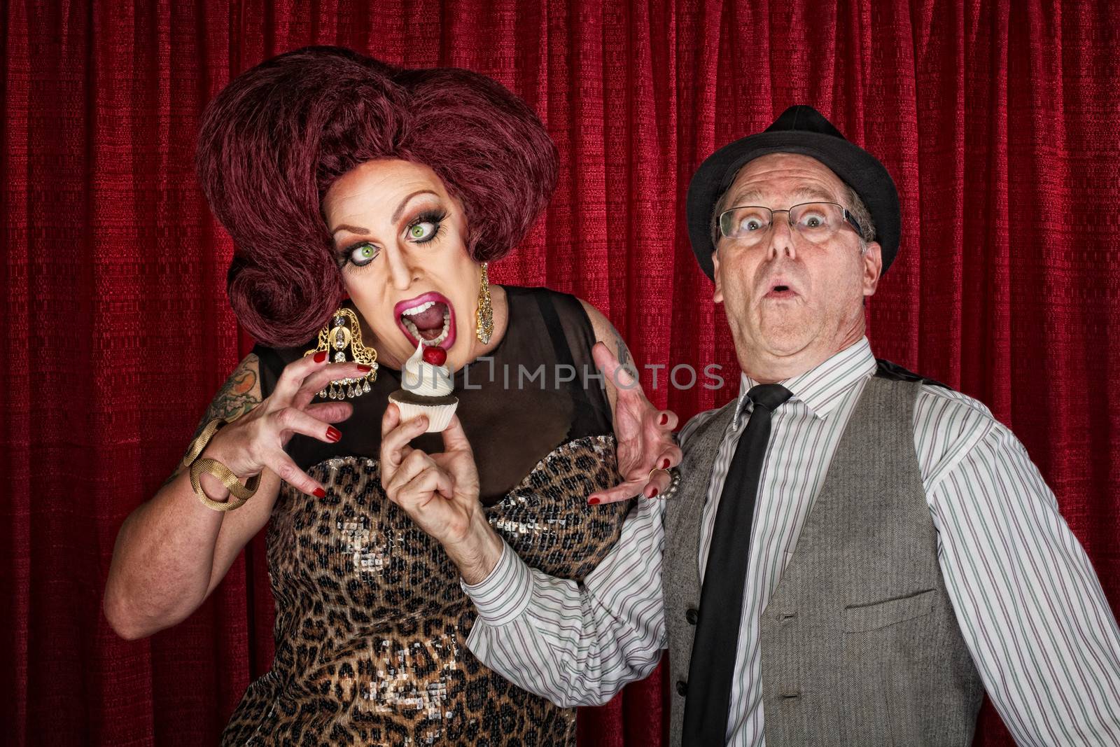 Hungry drag queen and friend holding cupcake