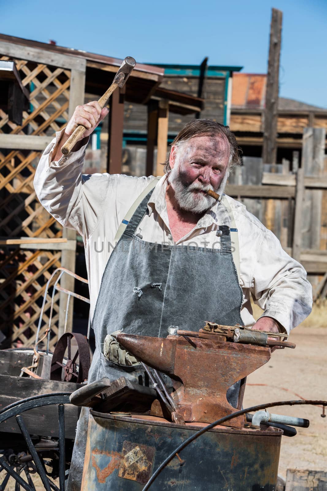 Old West Blacksmith Swings Hammer at an Anvil