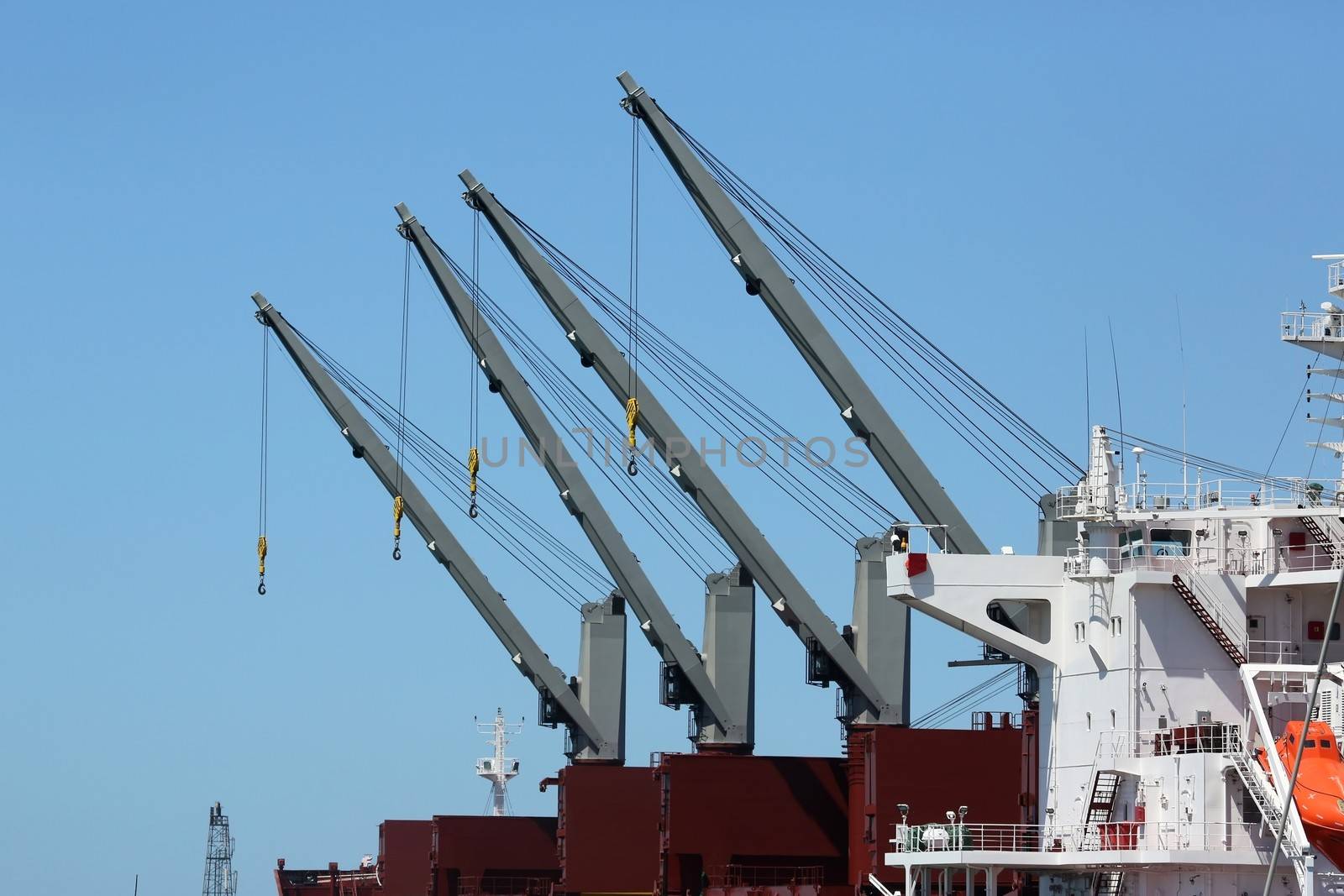 Four large cranes on board a cargo ship