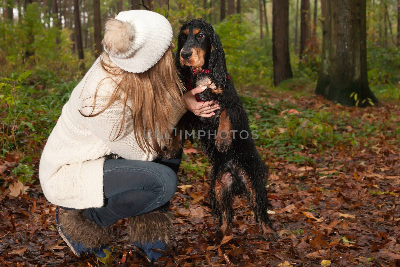 Girl and her dog are having a wet time in the rain