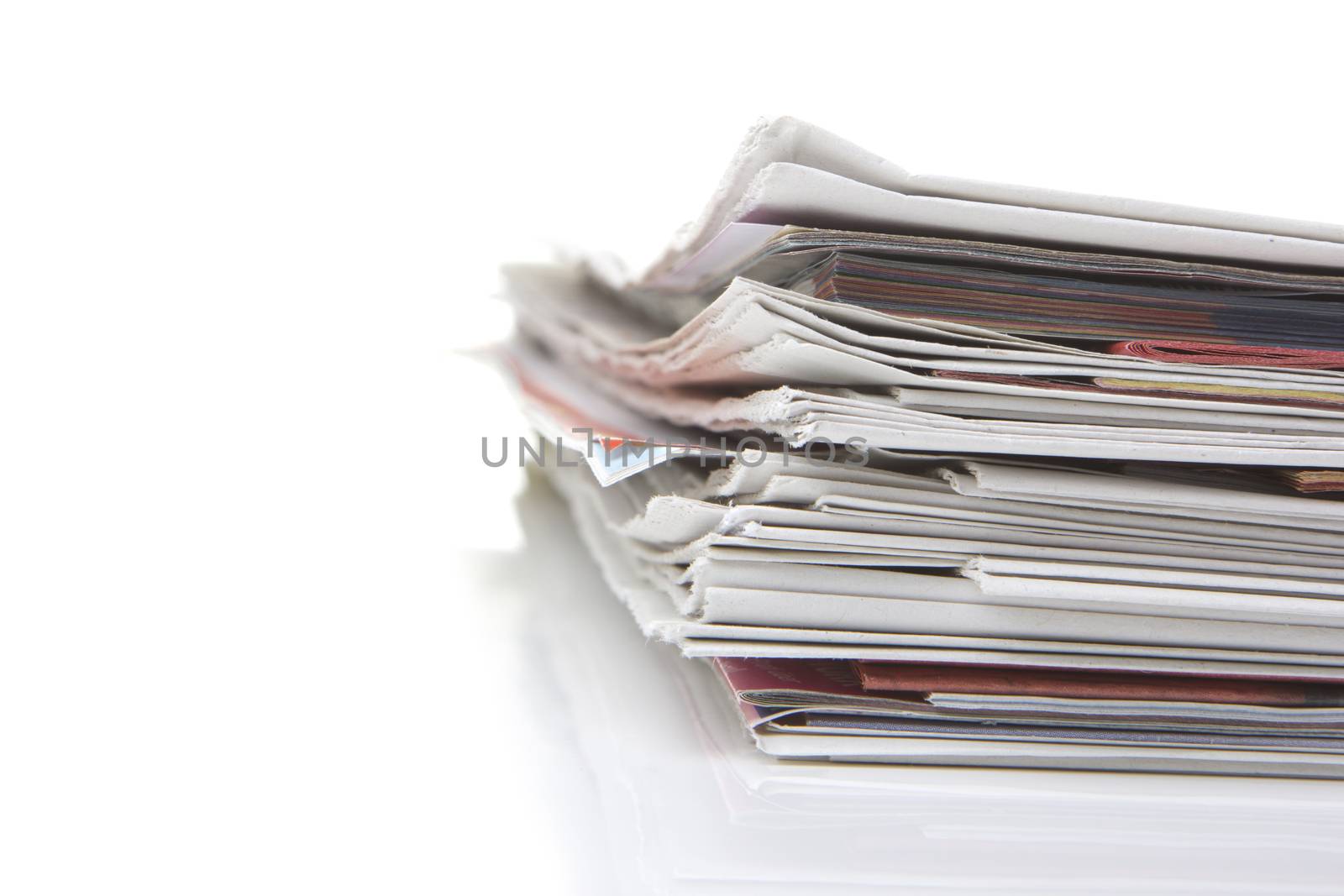 several newspapers, journals stacked on white background