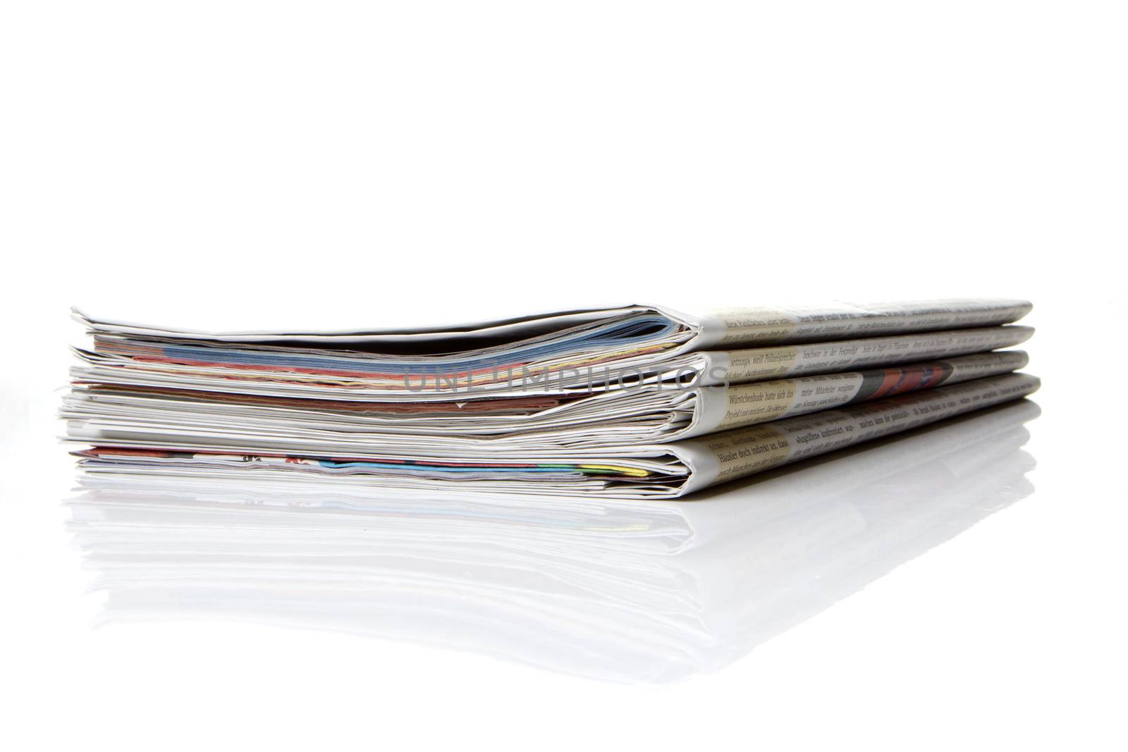 several newspapers, journals stacked on white background