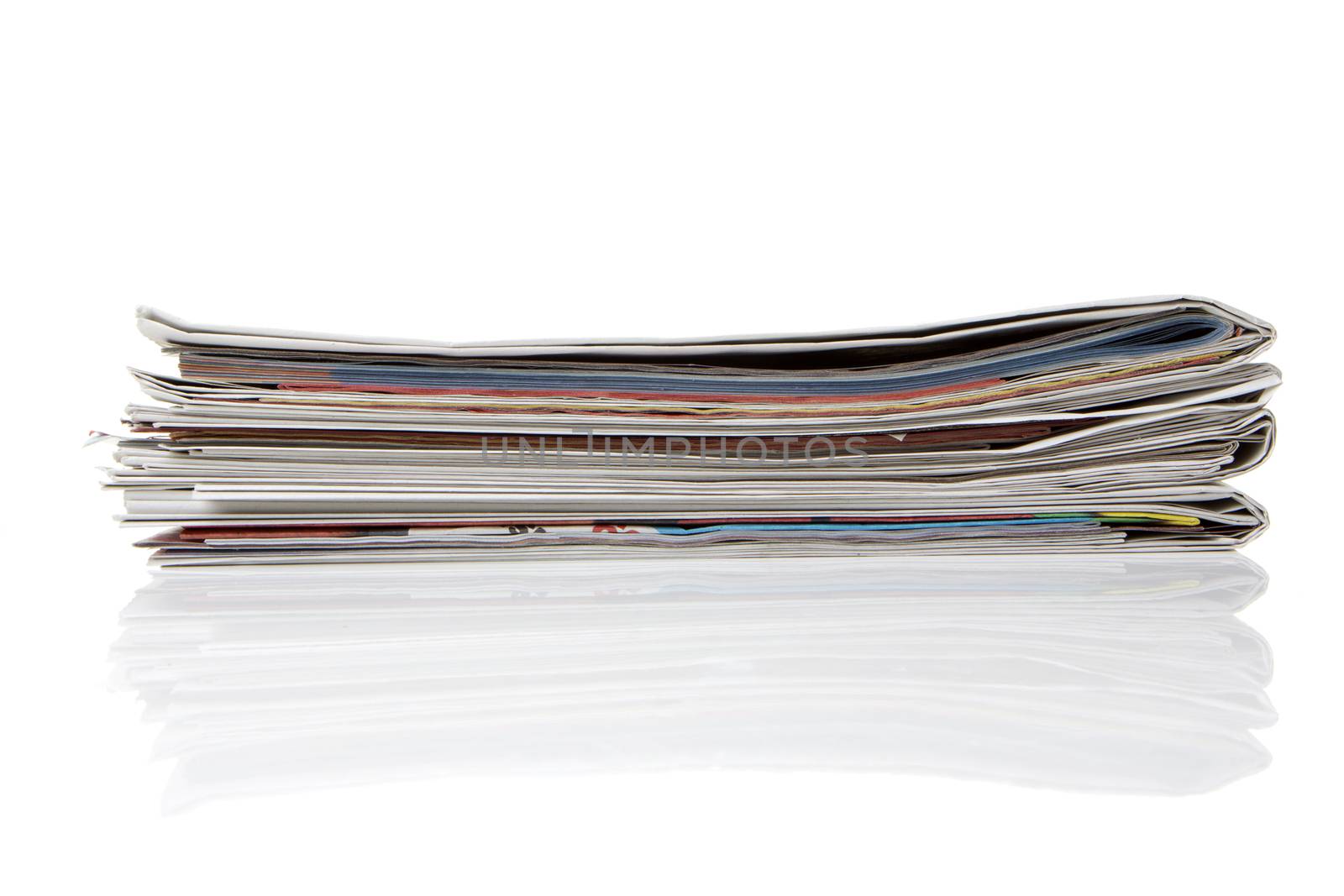 several newspapers, journals stacked on white background