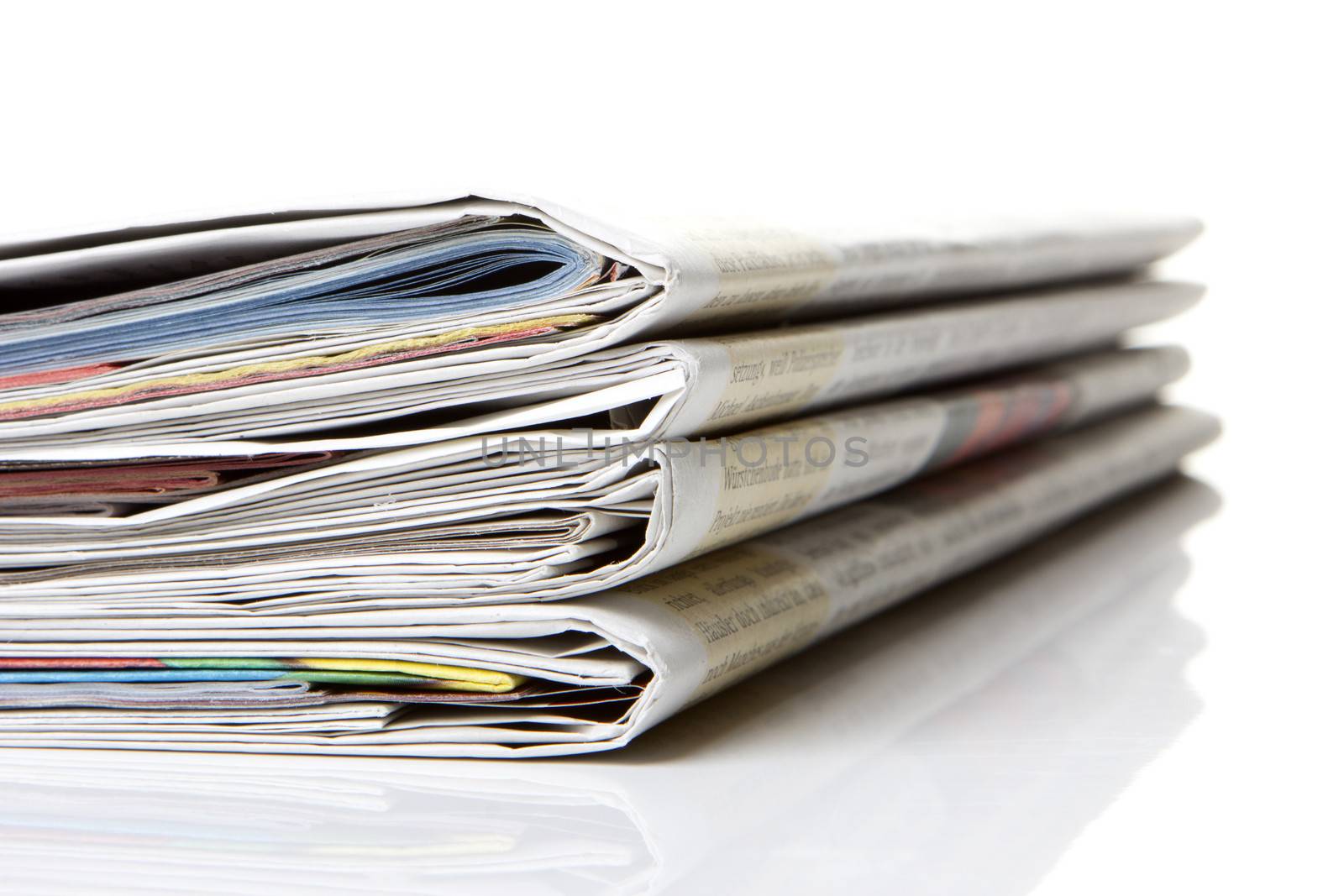 several newspapers, journals stacked on white background