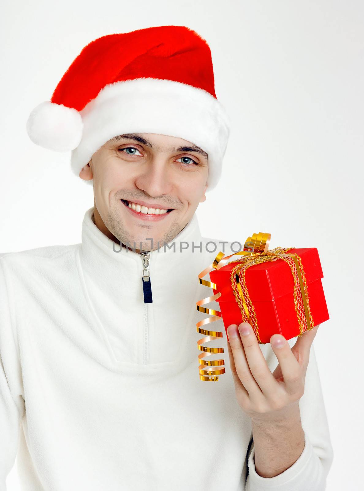 Attractive man in a Santa hat with Christmas gift