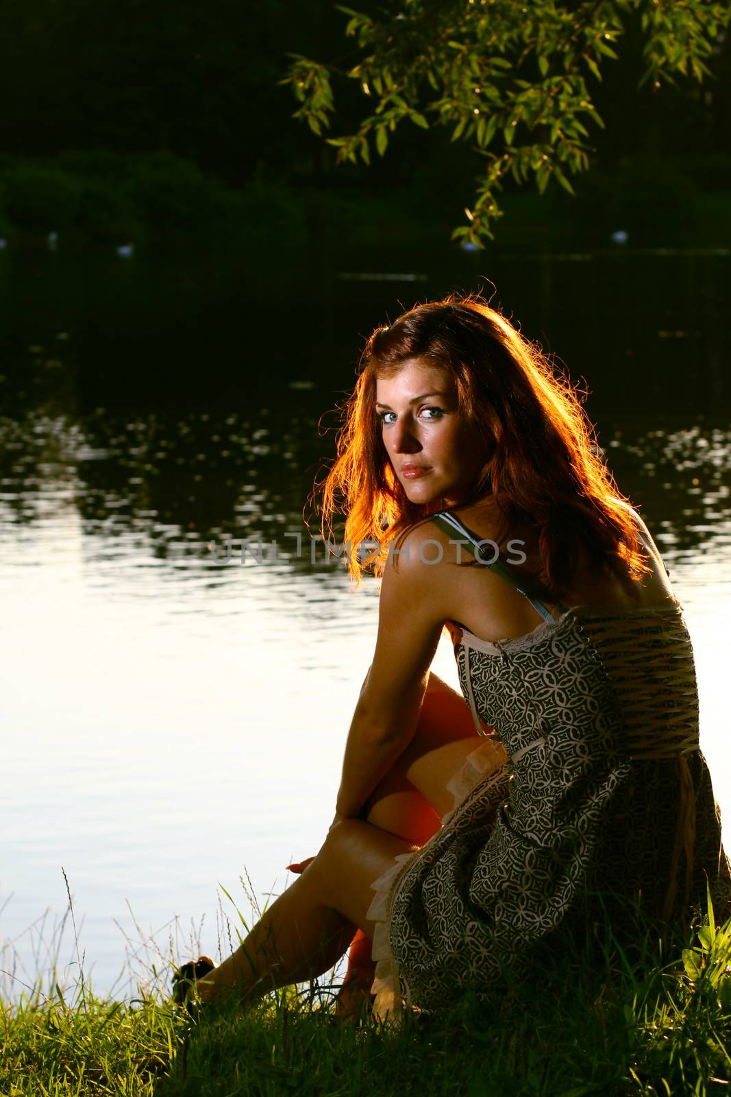 Girl sitting on tha bank of forest river