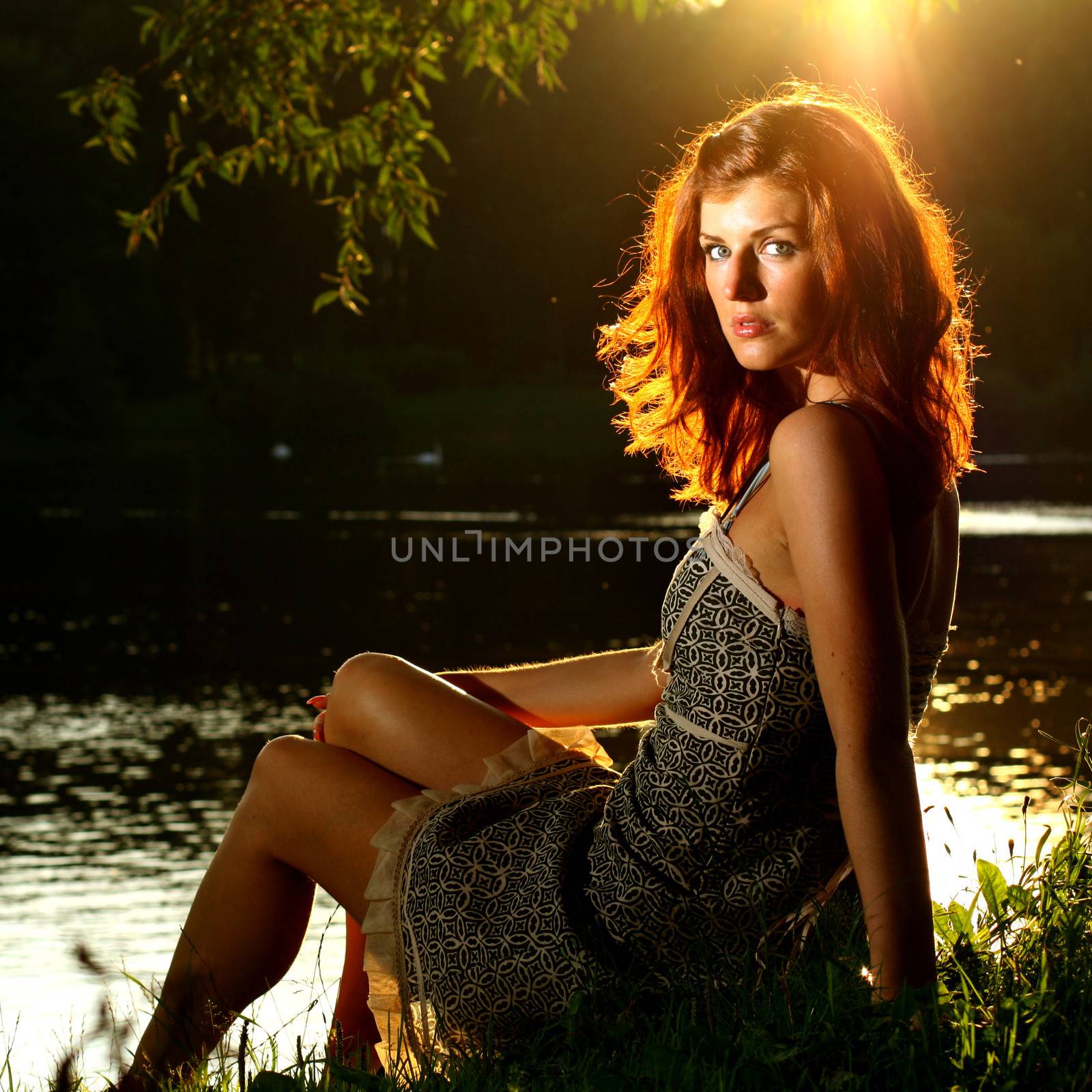 Girl sitting on tha bank of forest river