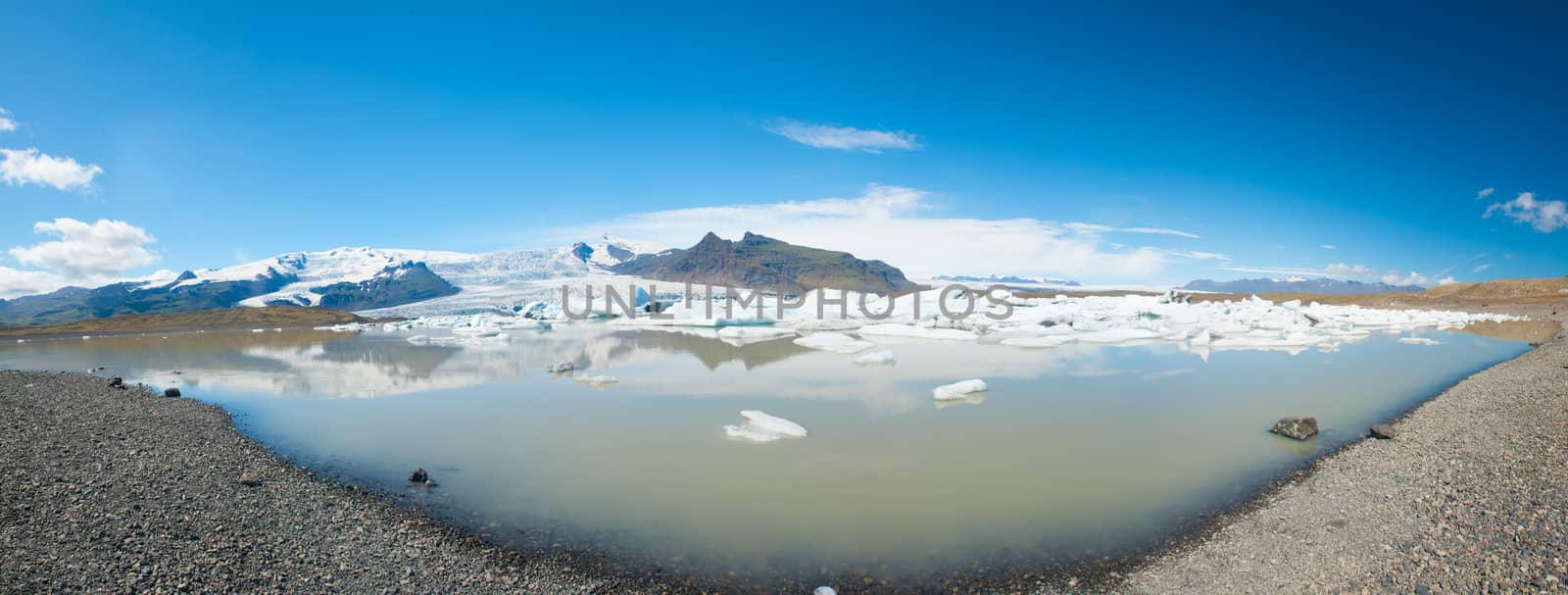 Beautiful panoramic photo of Fjallsarlon Glacial lake full of floating icebergs near the Fjallsjokull glacier