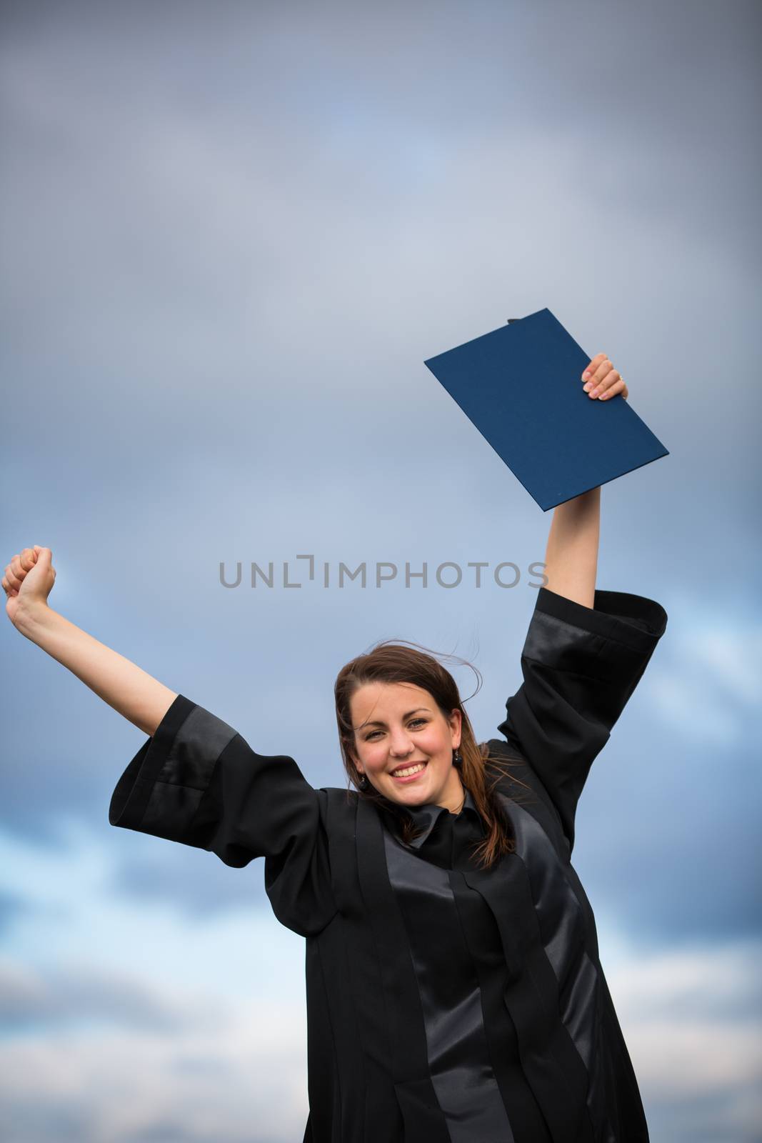 Pretty, young woman celebrating joyfully her graduation by viktor_cap