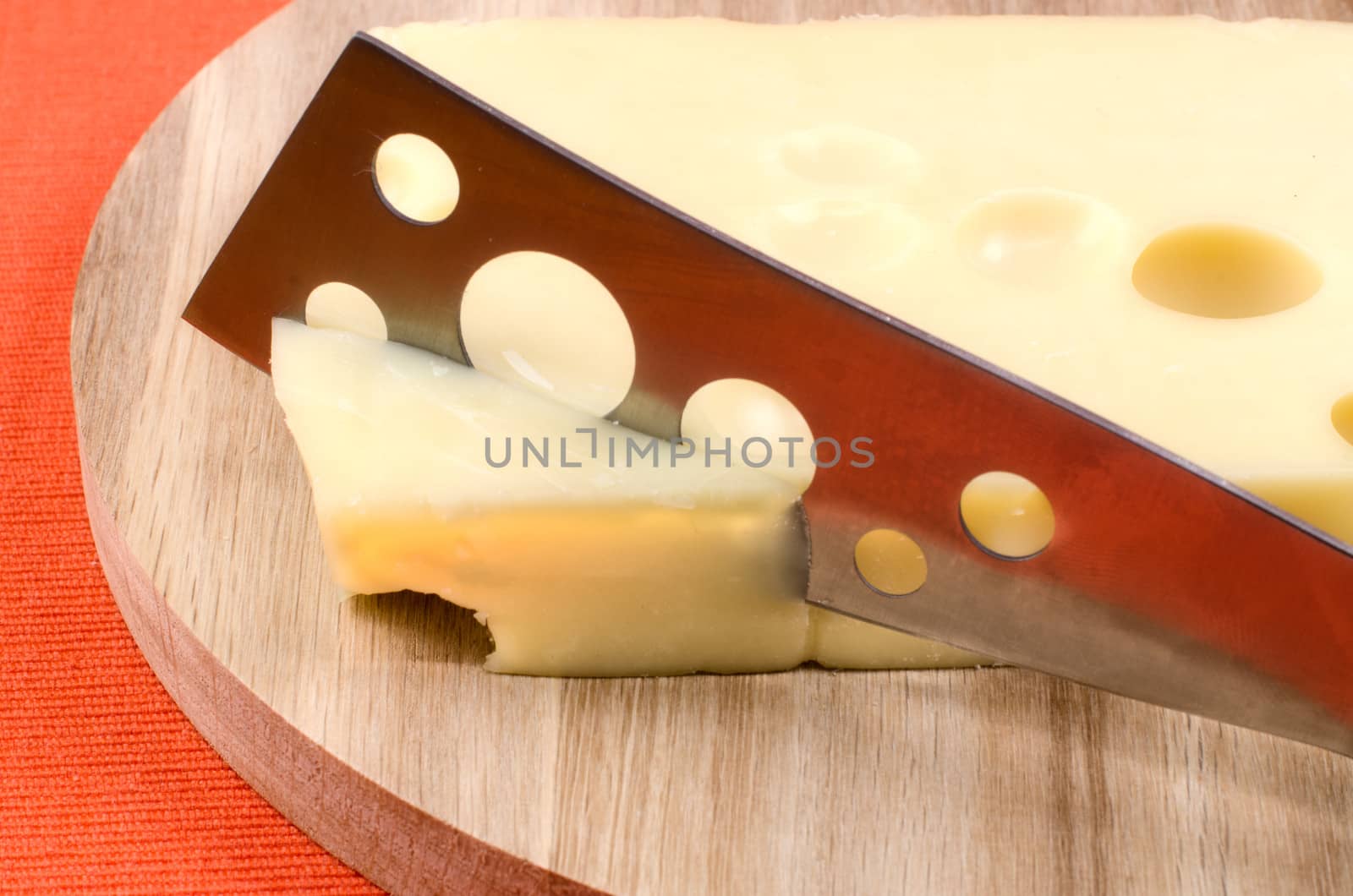 Cheese with a knife on a wooden board