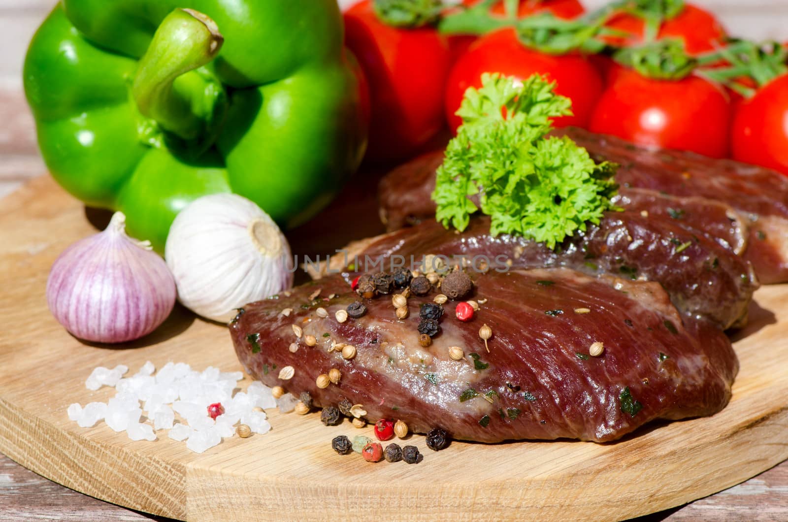 meat with fresh vegetables on wooden board