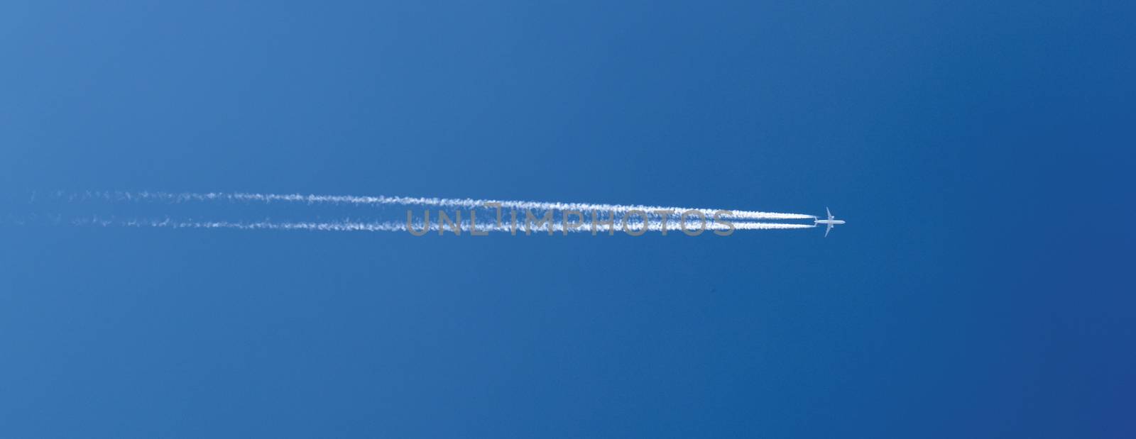 aircraft in a clear blue sky with condensation trail