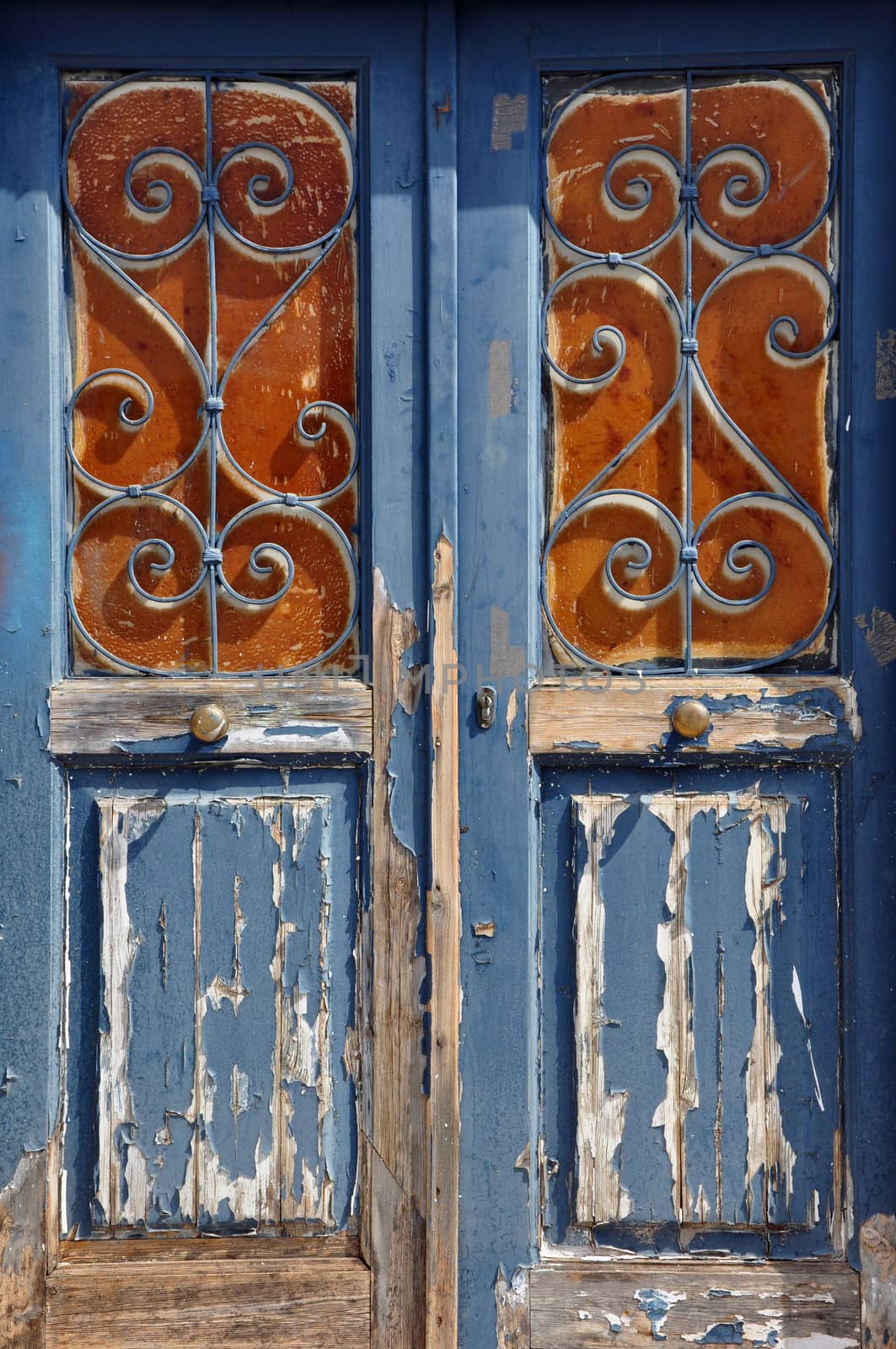 Old wooden door with vintage metal frame pattern and chipped paint texture.