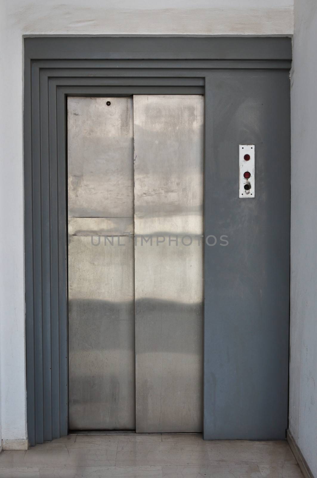 Elevator lift with metal sliding doors and control buttons.