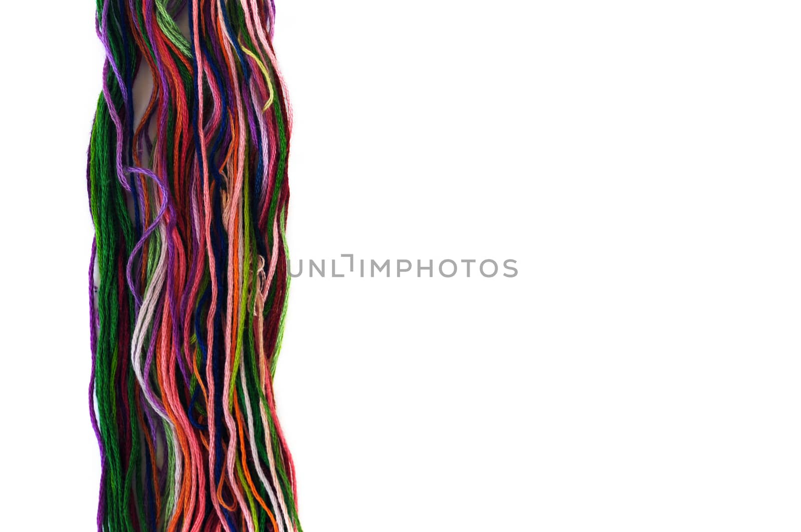 Multicolor sewing threads macro on white background.