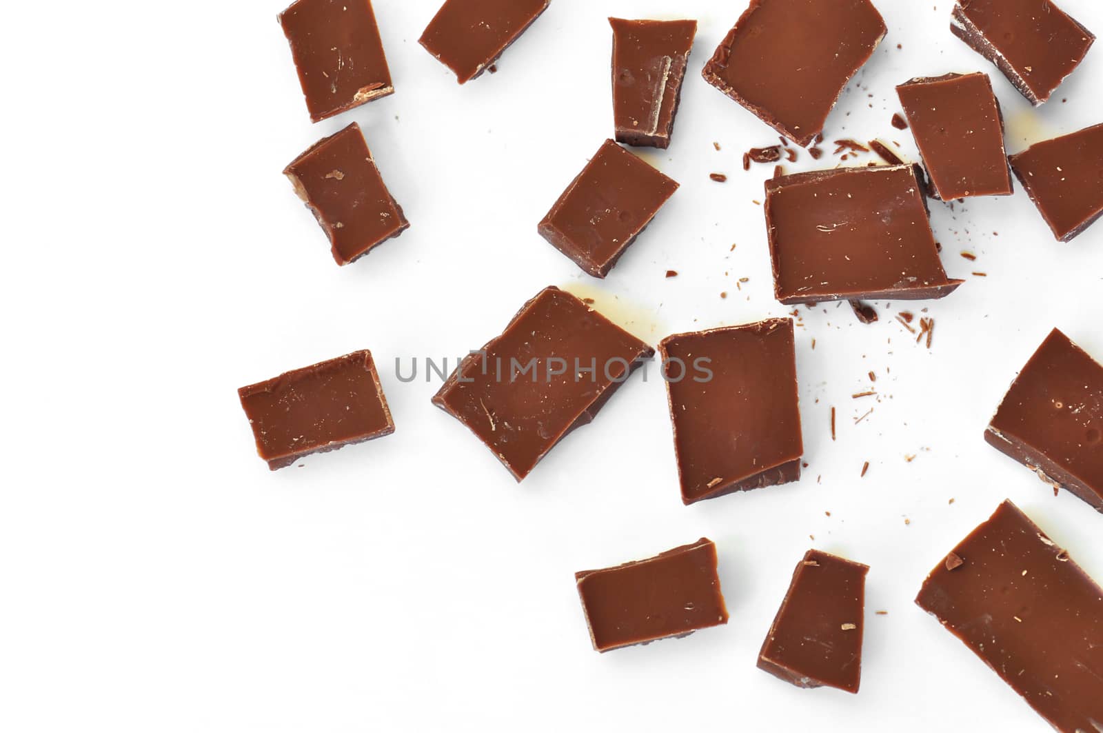 Pieces of milk chocolate on white background.