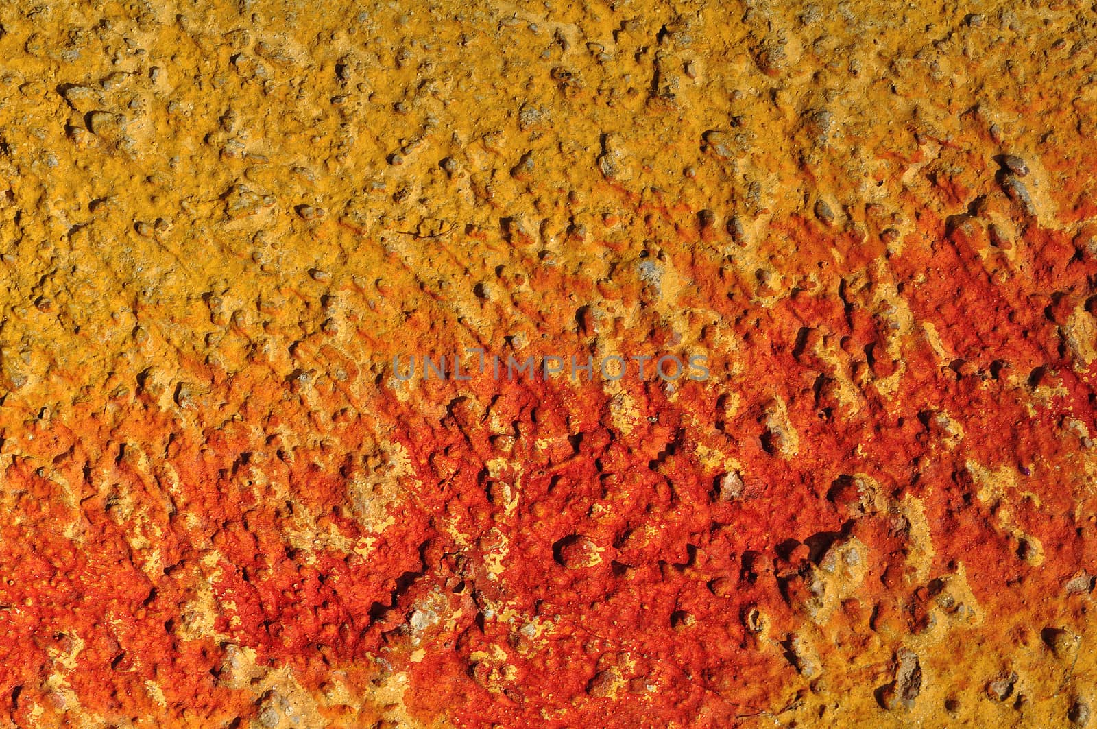 Red paint smudged on yellow textured wall background.