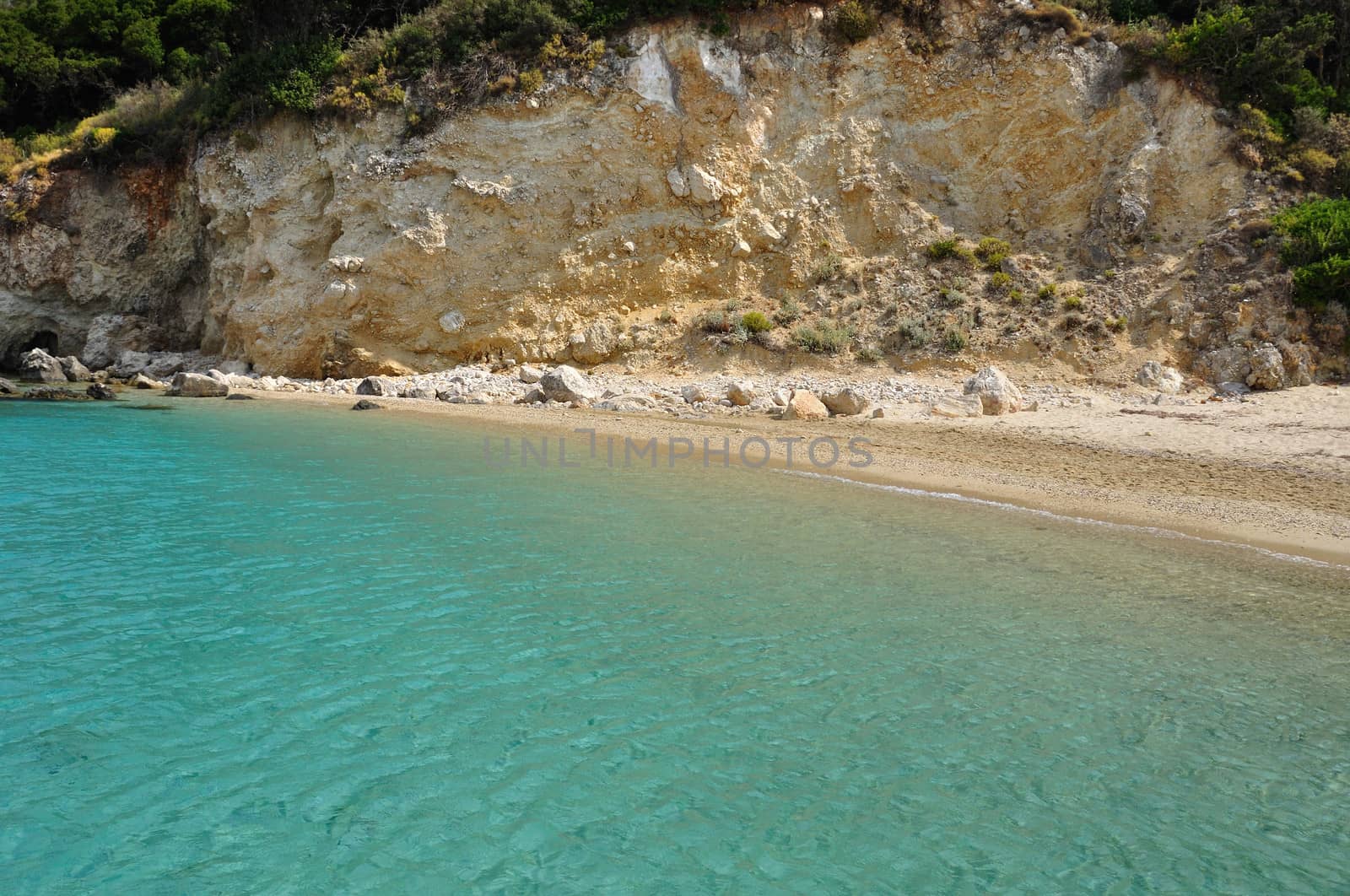 Turquoise sea water and sandy beach. Summer landscape eroded shore.