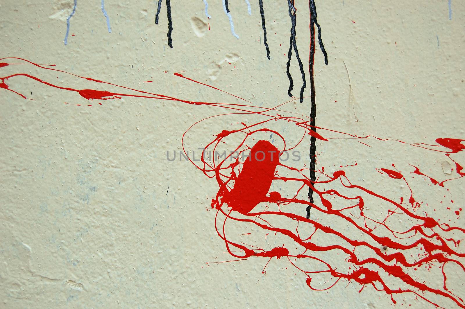 Red color splashed on white textured wall. Dripping paint abstract background.