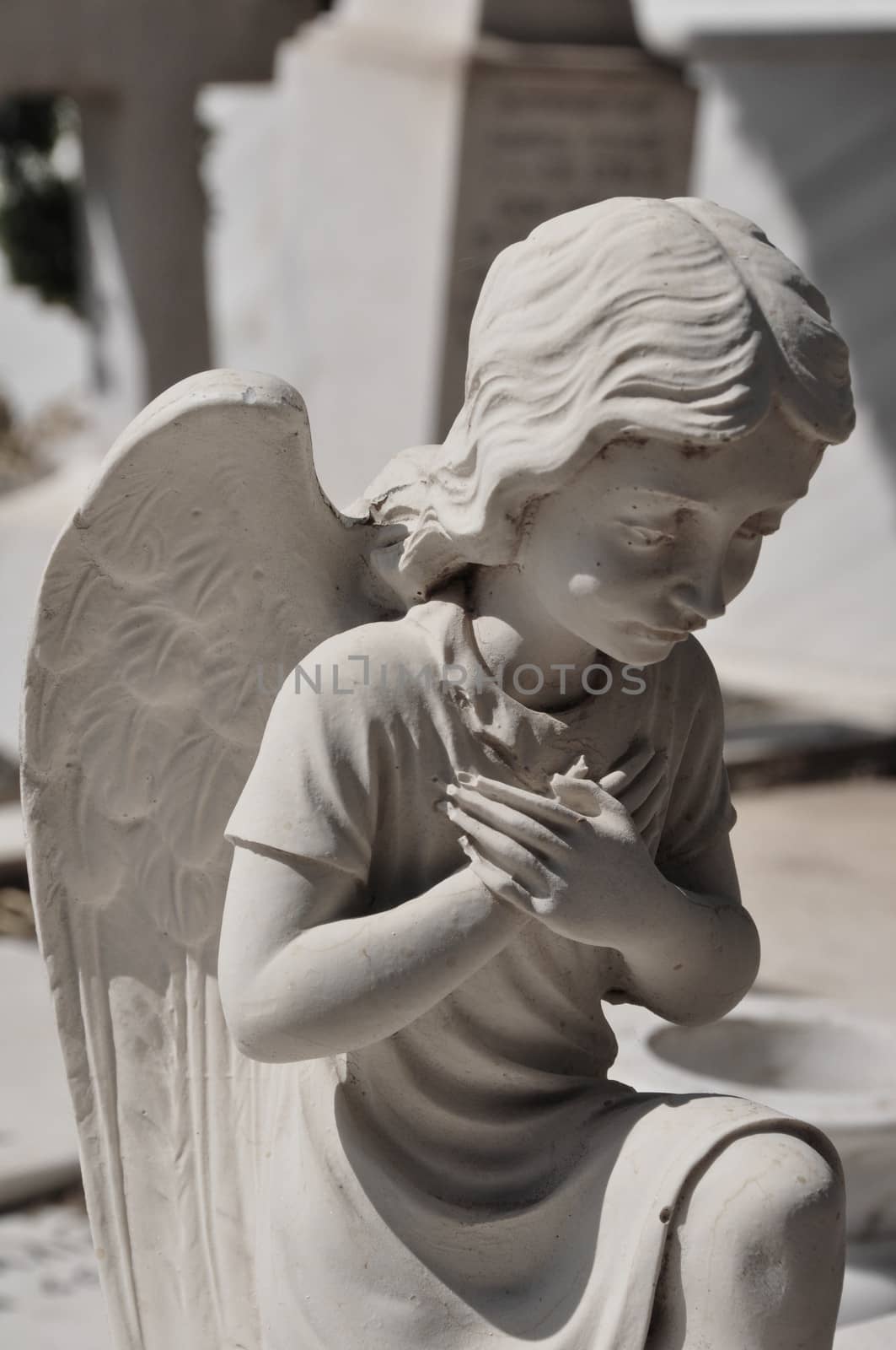 Praying angel marble funerary statue. Mourning cherub abstract.