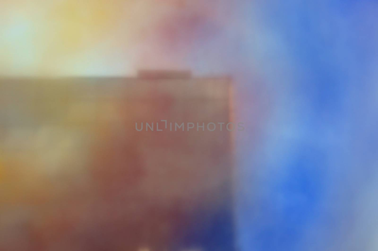 Blurry building exterior through colorful smudged glass. Architecture abstract.