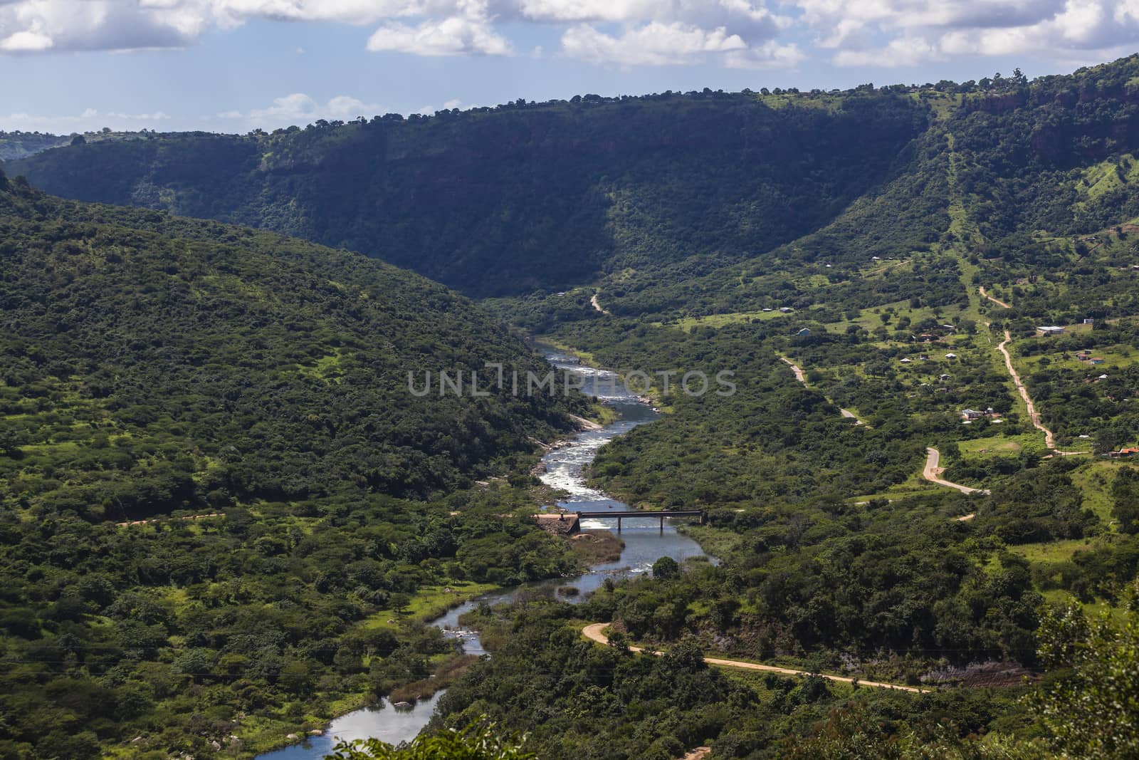 Summer green valley with river water flowing briskly through the terrain landscape