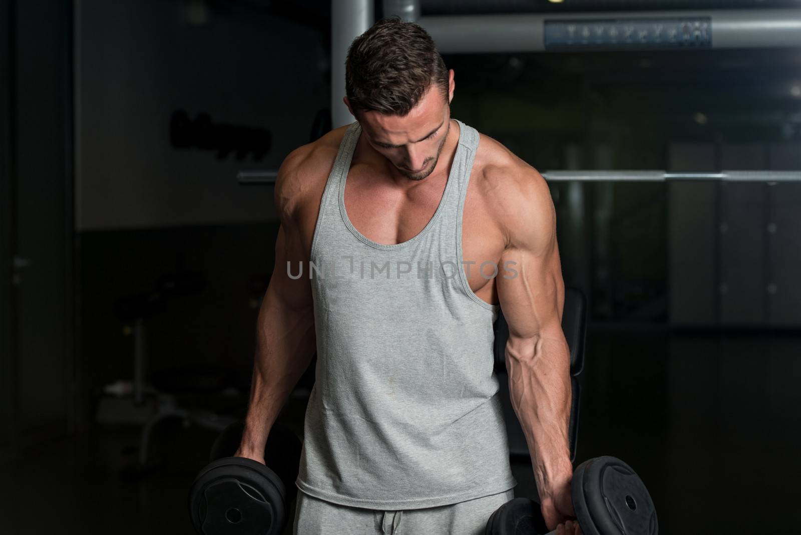 Young Muscular Man Lifting Weights by JalePhoto