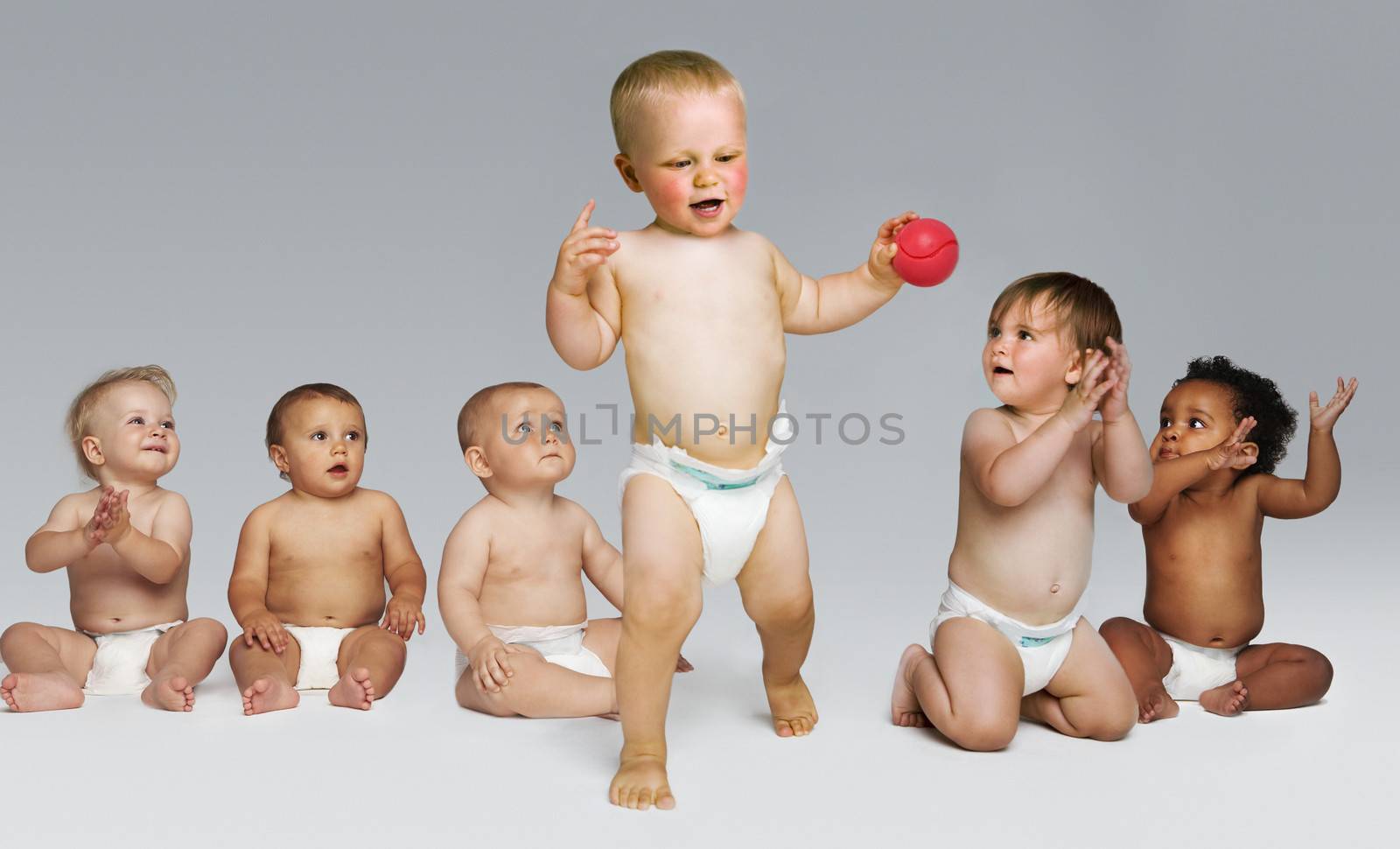 Toddler takes first steps encouragement of other babies by moodboard