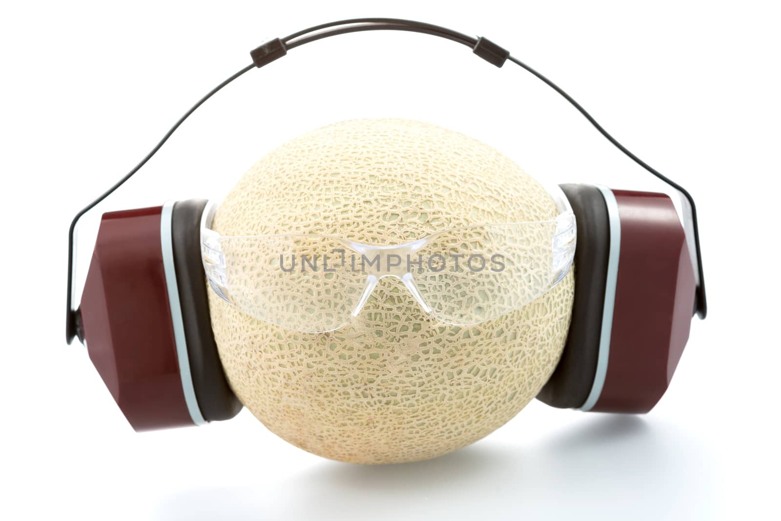 Industrial protective headphones and safety glasseson on the melon, isolated on white background