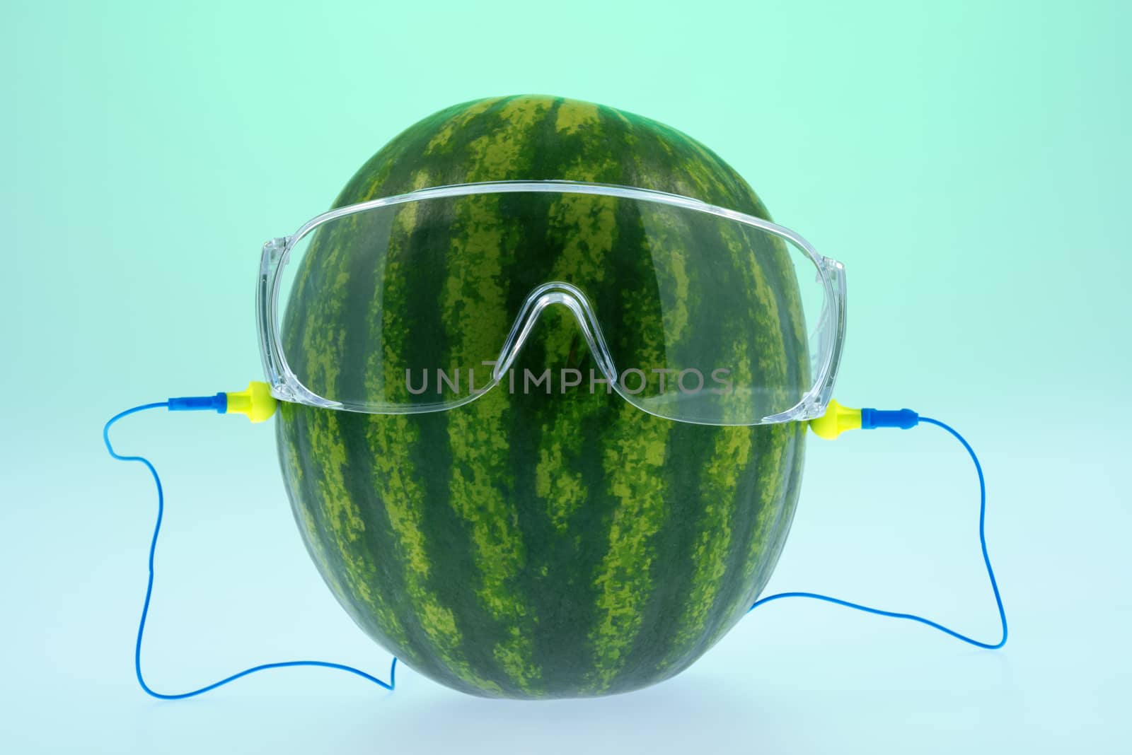 Melon safety glasses and ear plugs composition on green