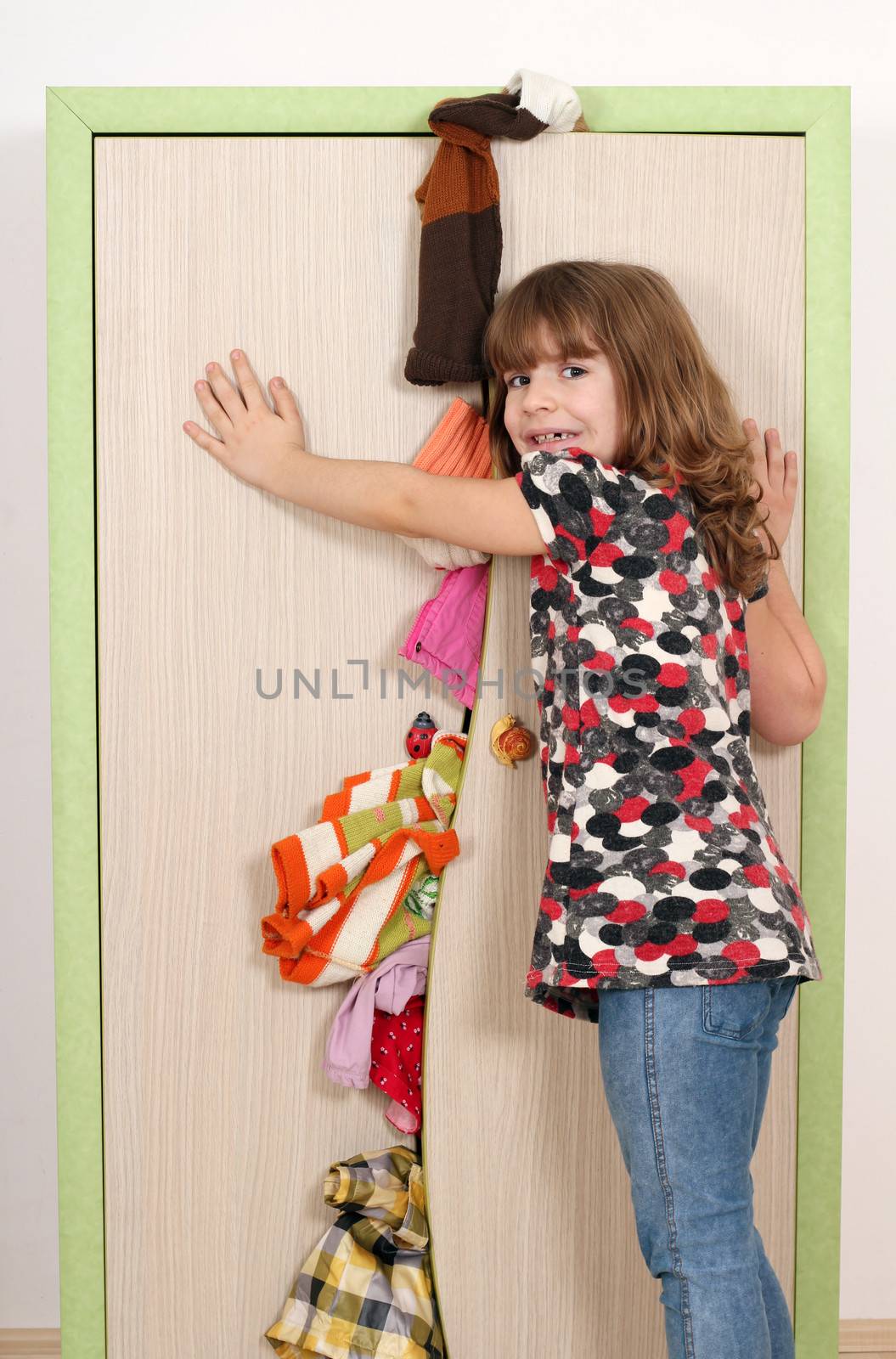 upset little girl trying to close the closet 