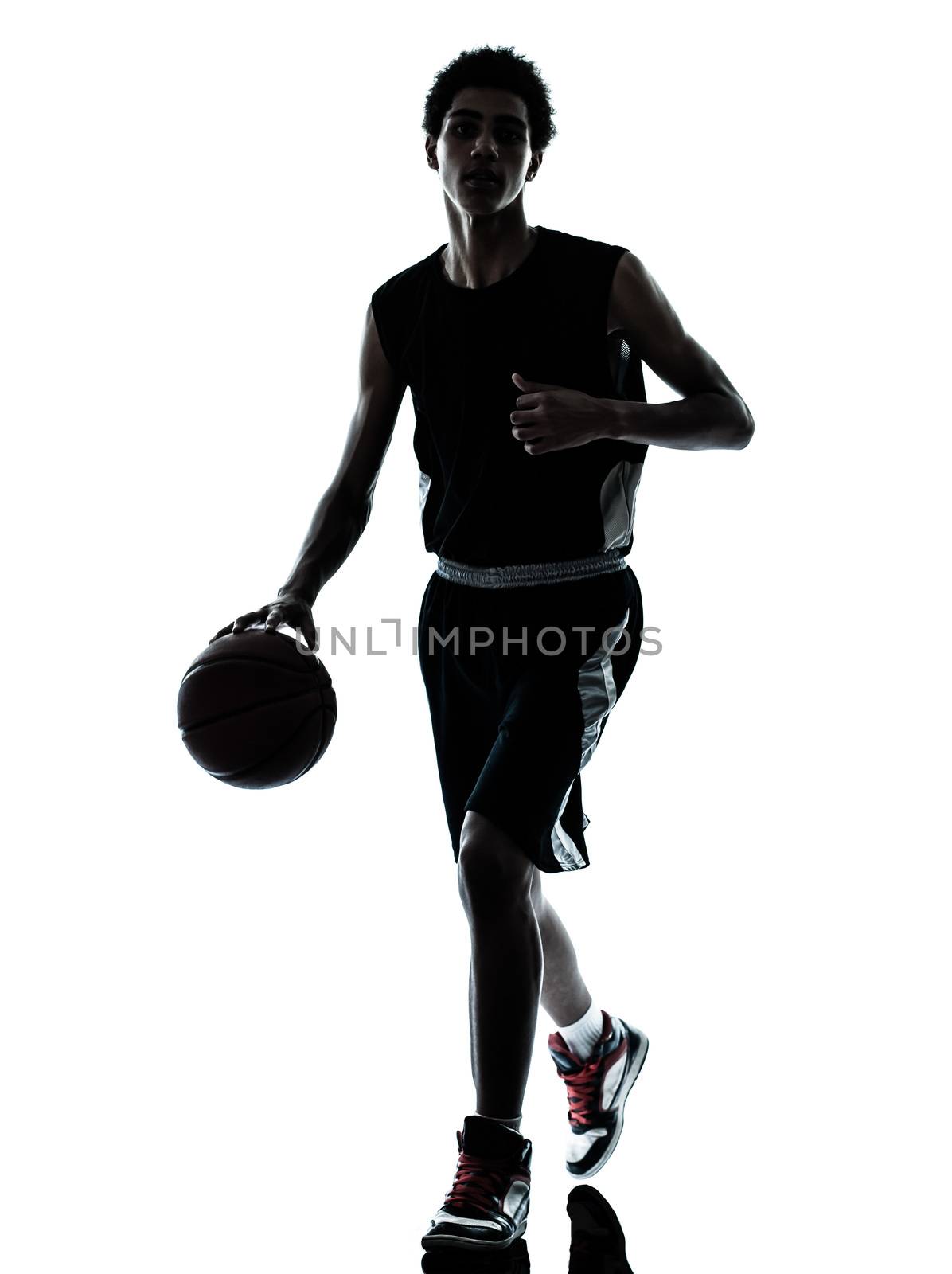 one young man basketball player dribbling silhouette in studio isolated on white background