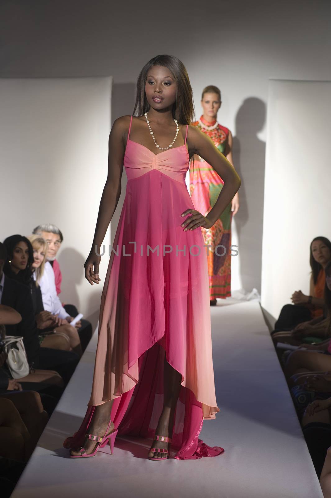 Woman in pink dress on fashion catwalk by moodboard