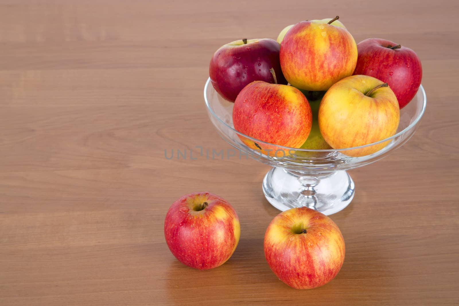 Apples in a glass on wooden background.