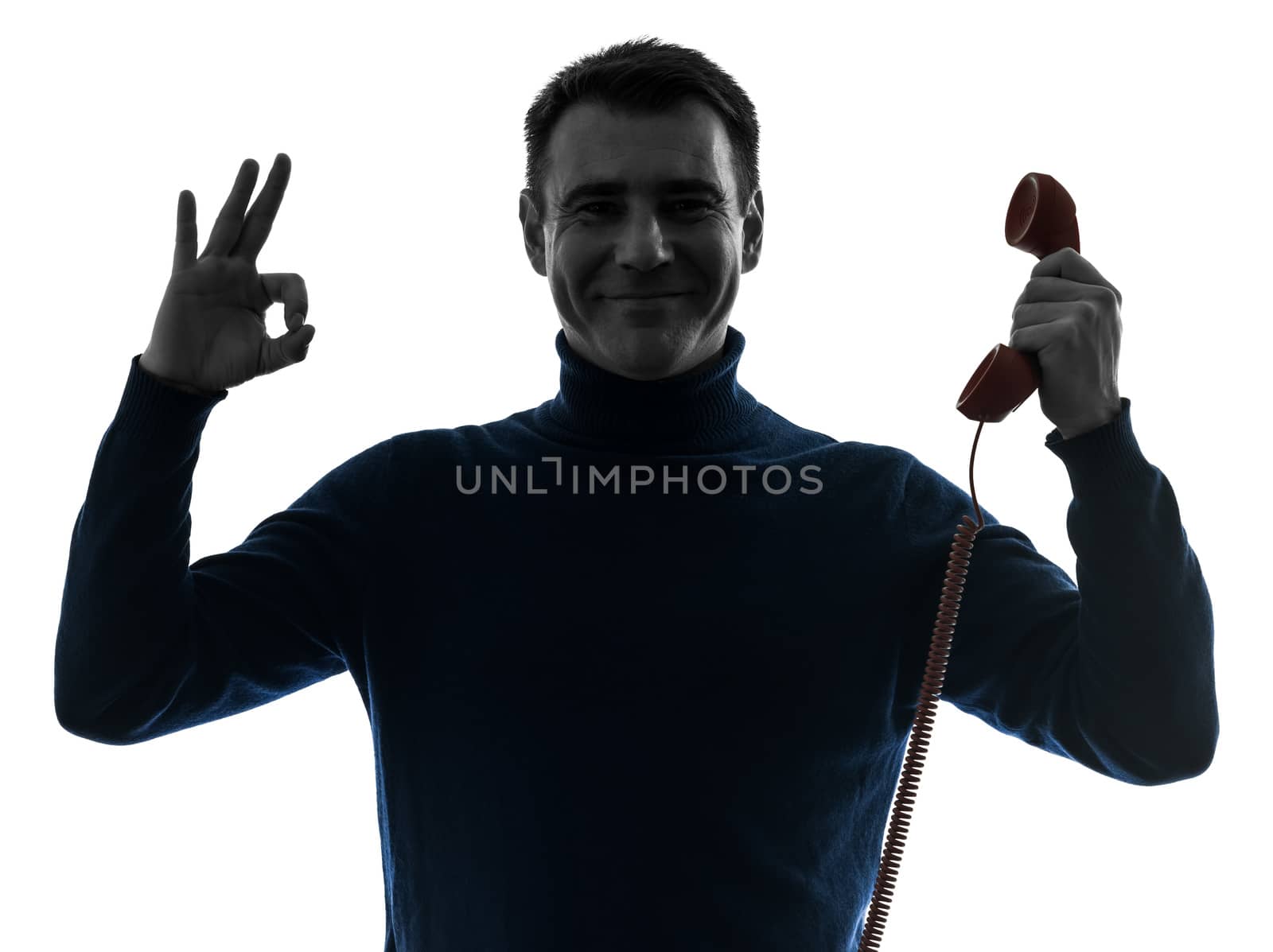 one caucasian man on the phone ok sign portrait in silhouette studio isolated on white background