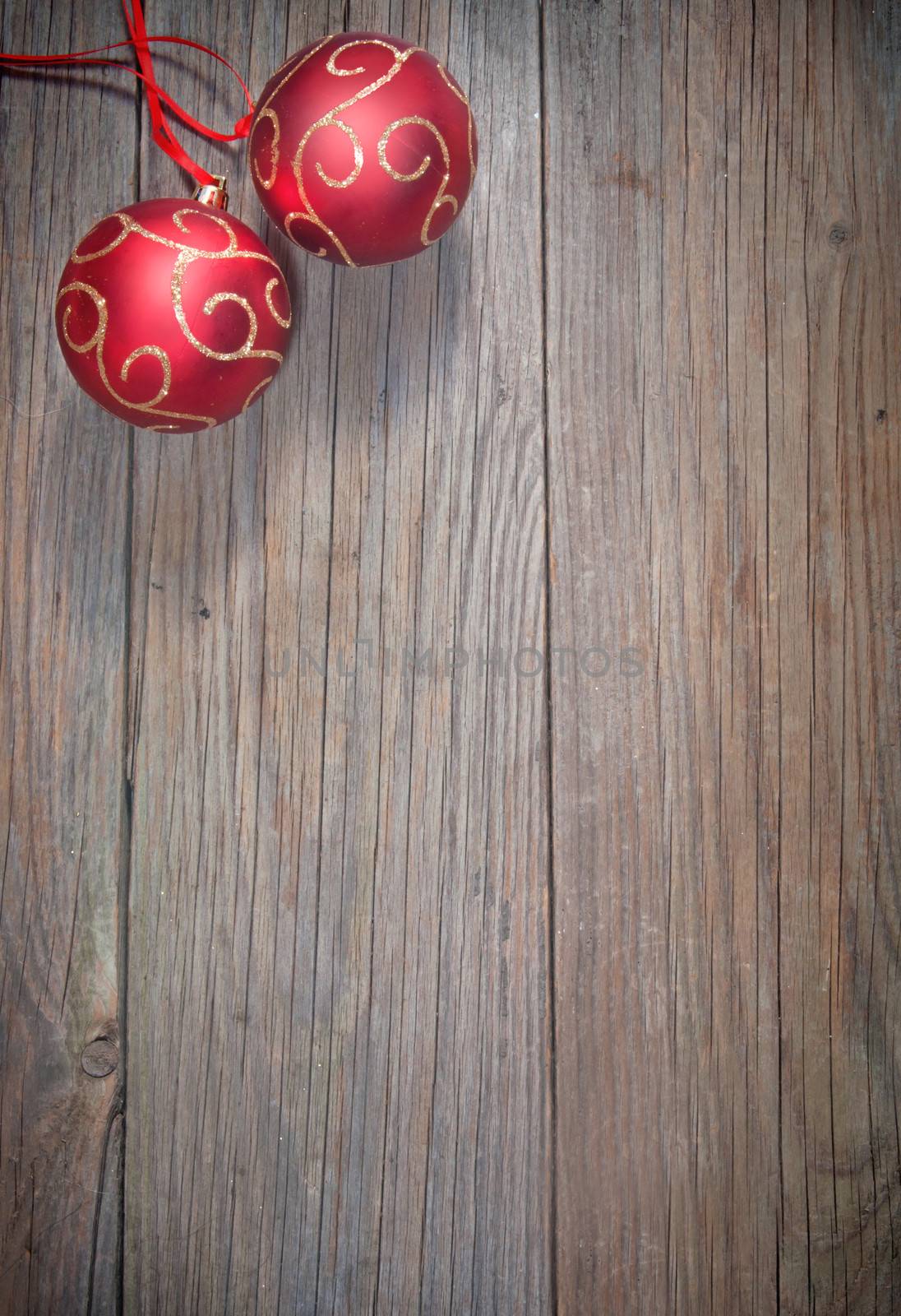Christmas baubles with a red ribbon frame on a wood texture