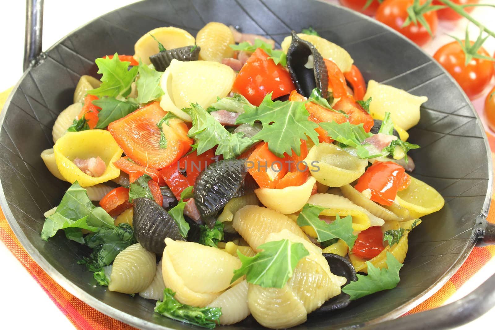 Pasta pan with bell pepper, tomatoes and garlic on a light background