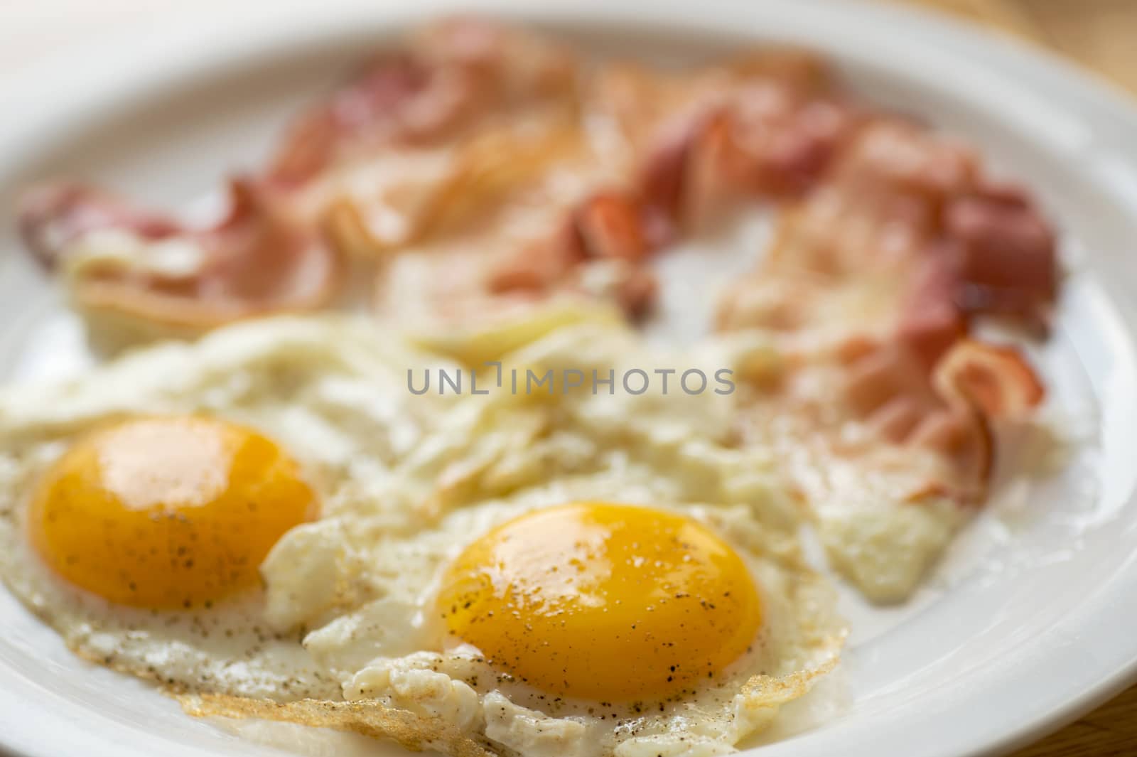 Two fried eggs and bacon on the plate
