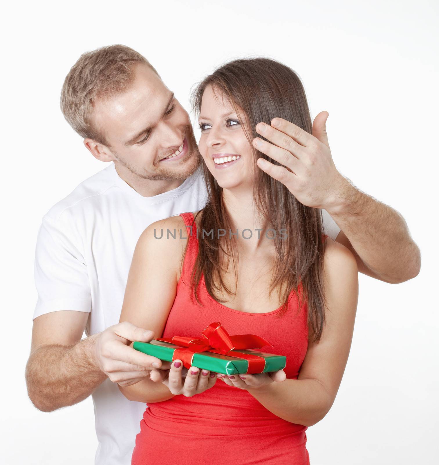 young man giving his girlfriend a surprise present by courtyardpix