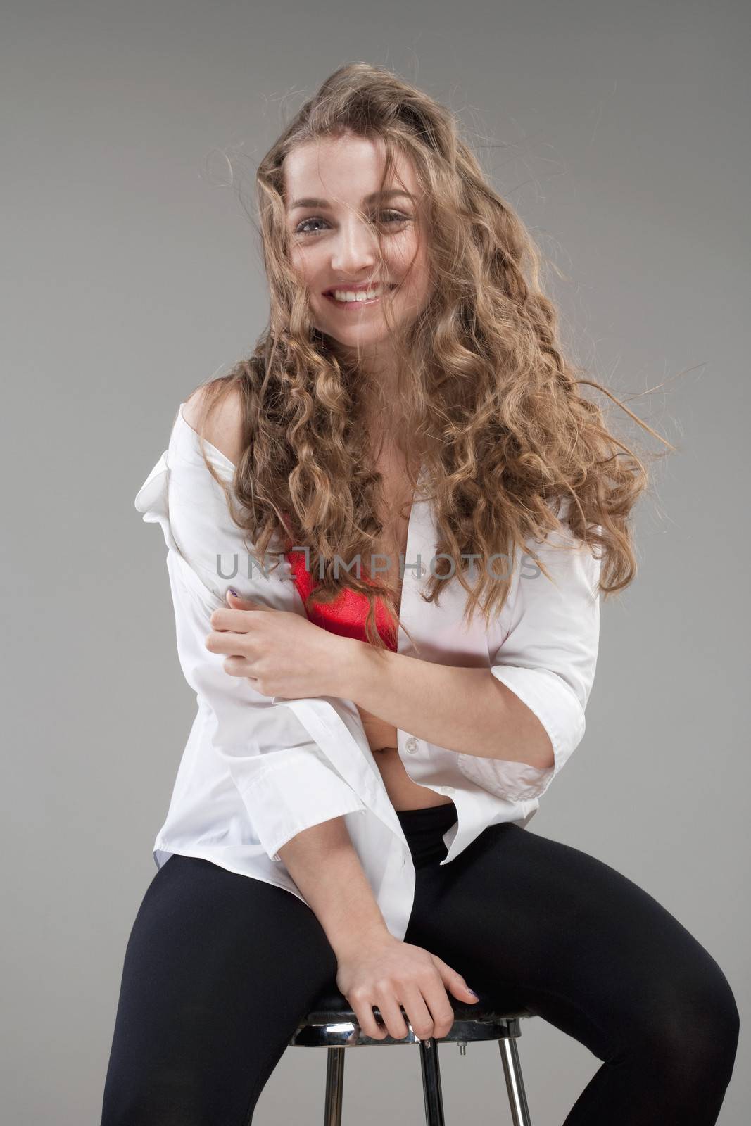 portrait of a young beautiful woman with brown hair smiling - isolated on gray