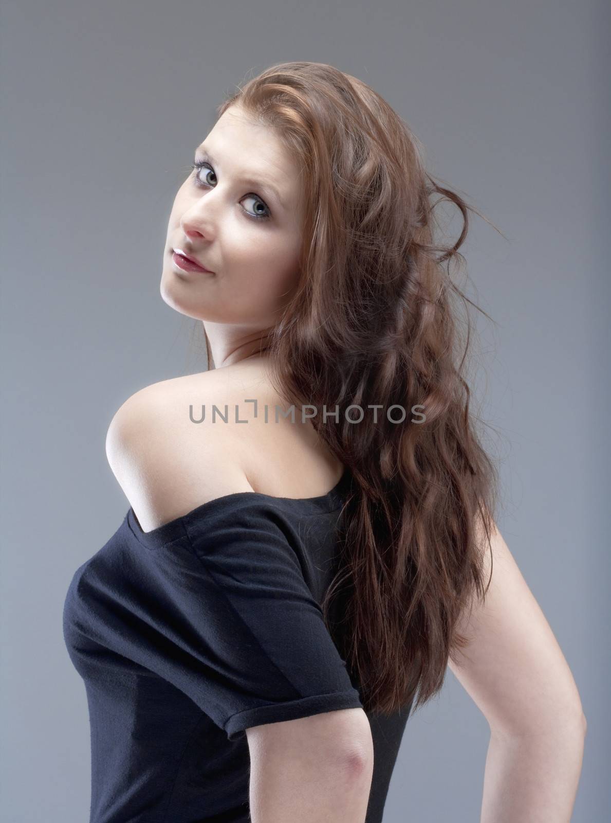 portrait of a young beautiful woman with brown hair - isolated on gray