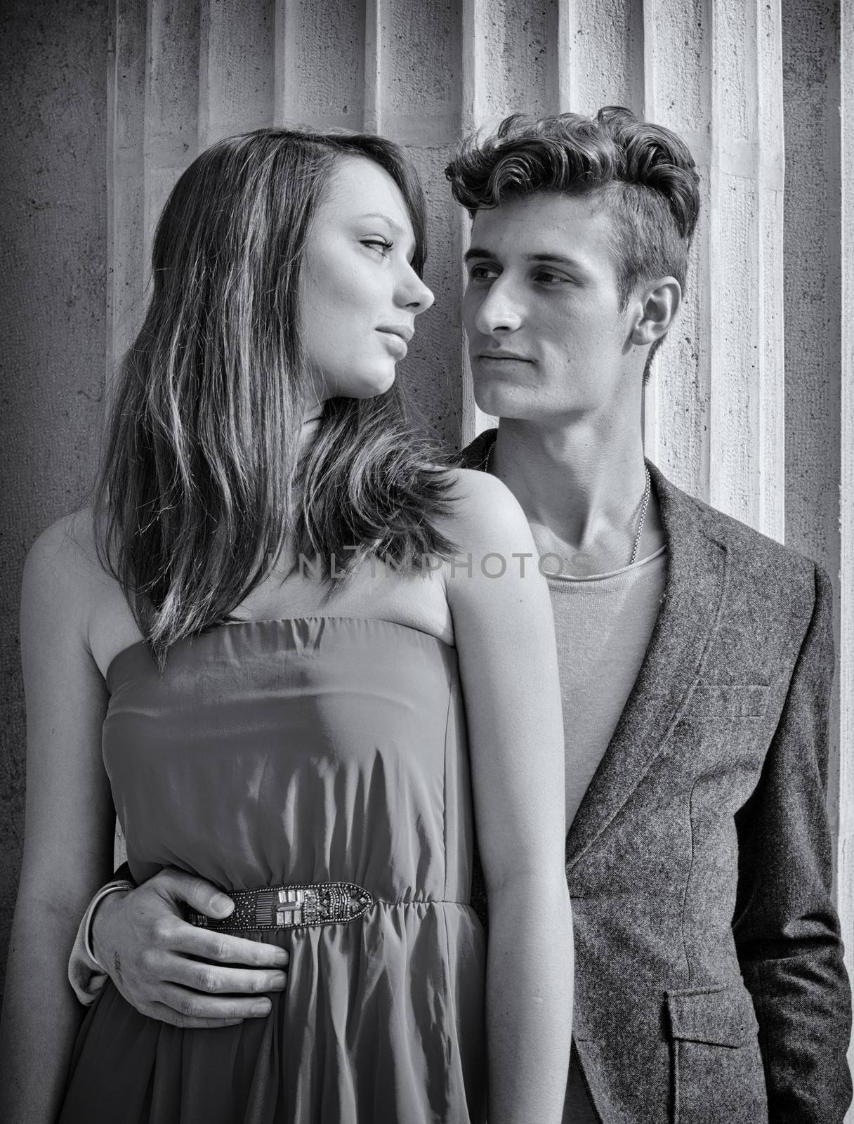 Elegant young couple next to old stone column by artofphoto