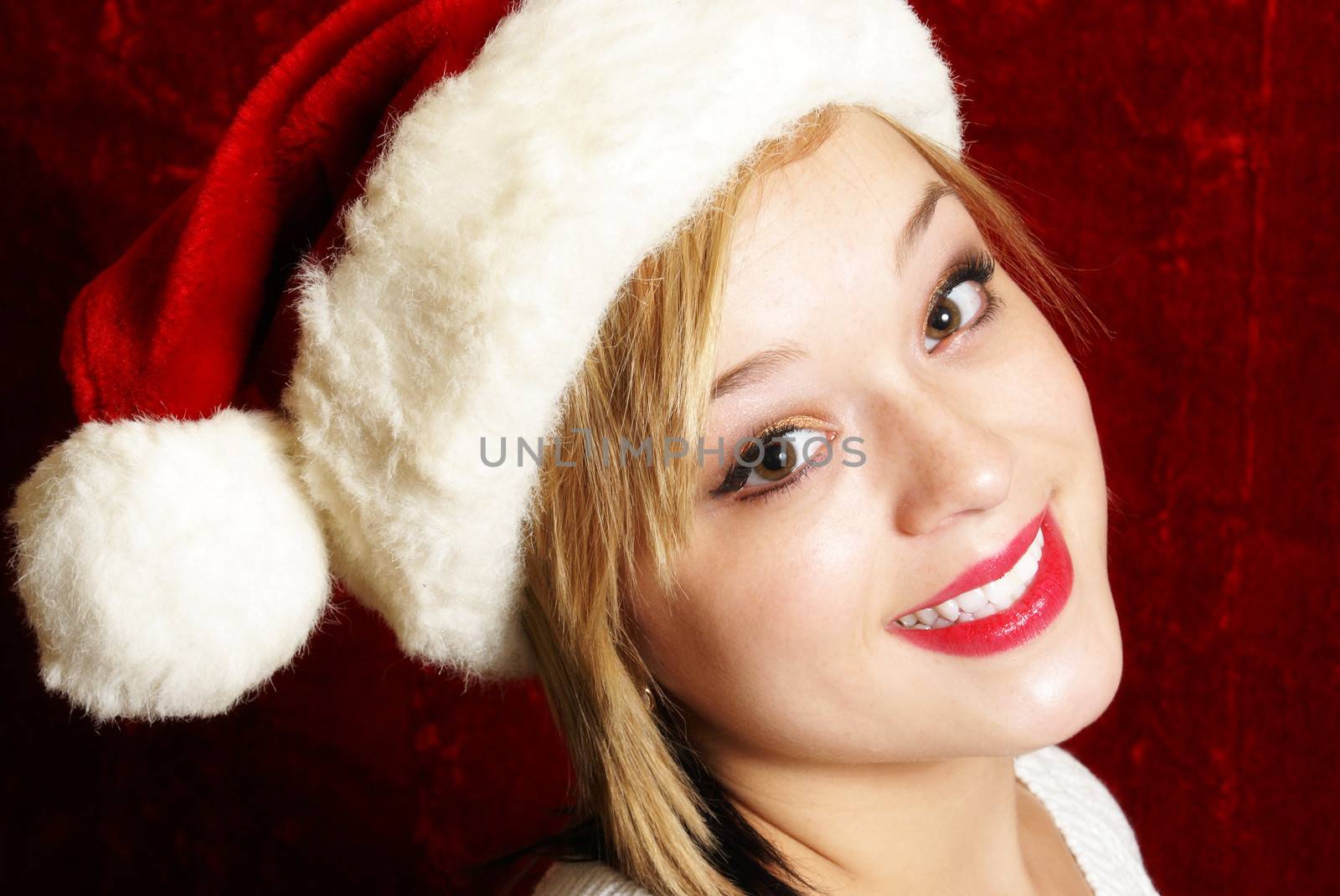 A happy young woman wearing a santa hat for the spirit of Christmas.