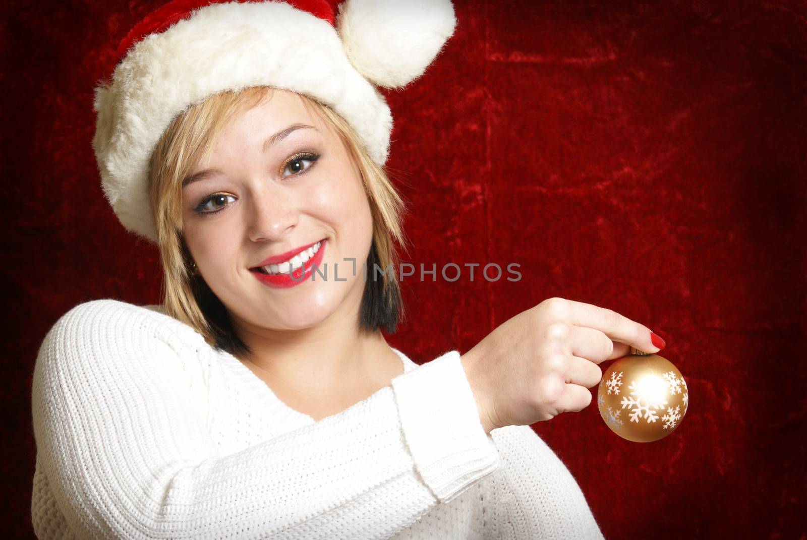 A beautiful woman holds a Christmas bauble as she gets ready to decorate.