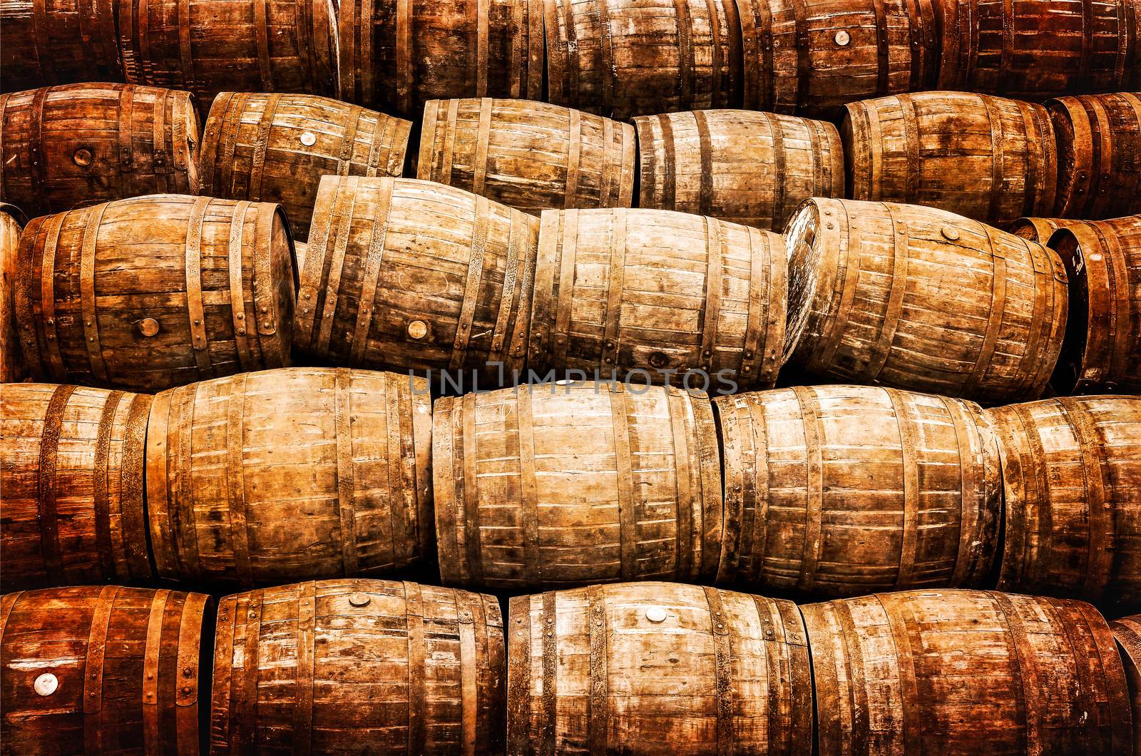 Stacked pile of old vintage whisky and wine wooden barrels by martinm303