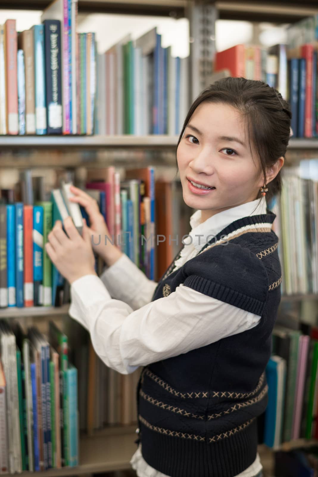 Portrati of student in front of bookshelf by IVYPHOTOS