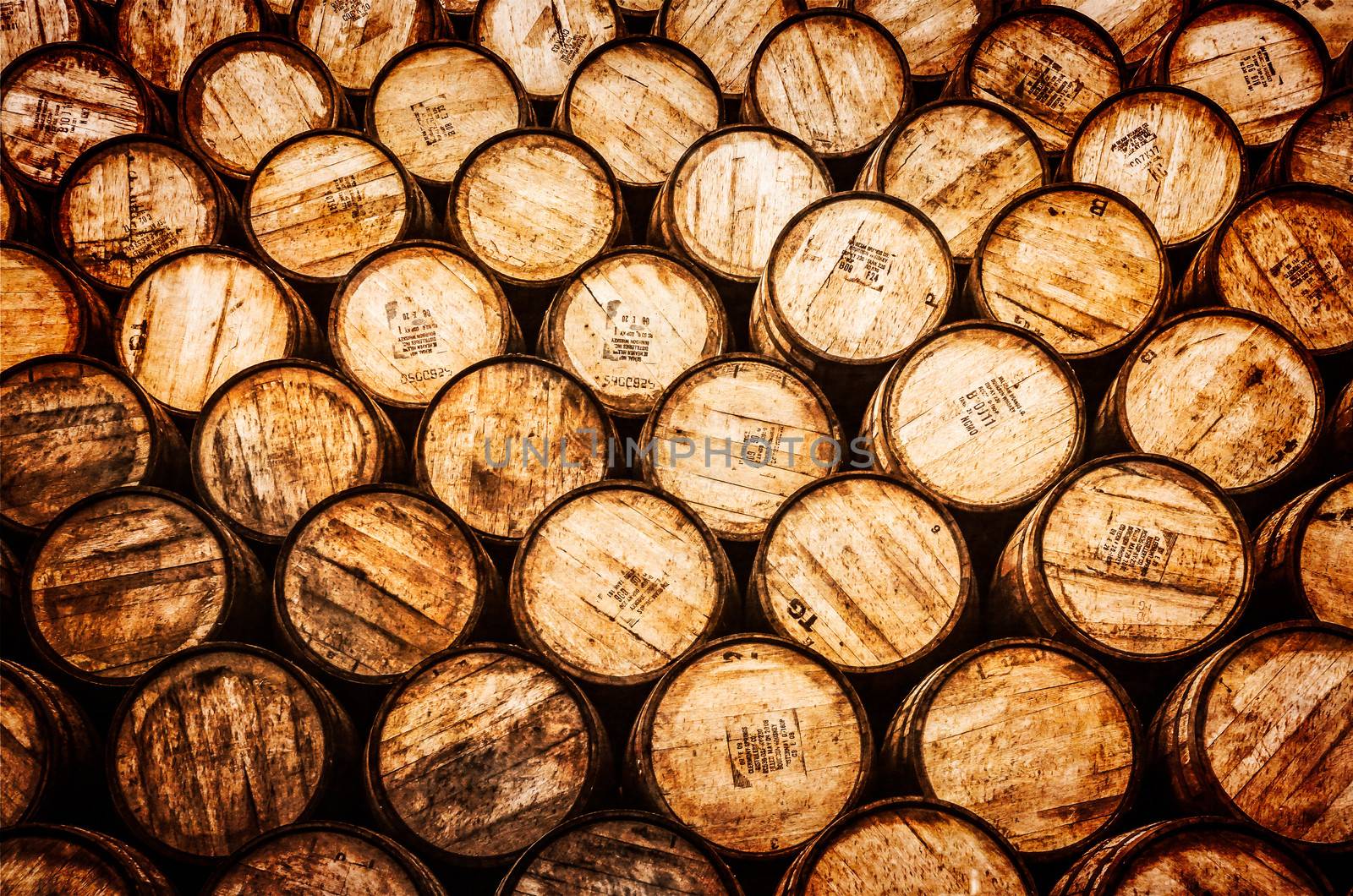 Detail view of stacked whisky and wine wooden barrels by martinm303