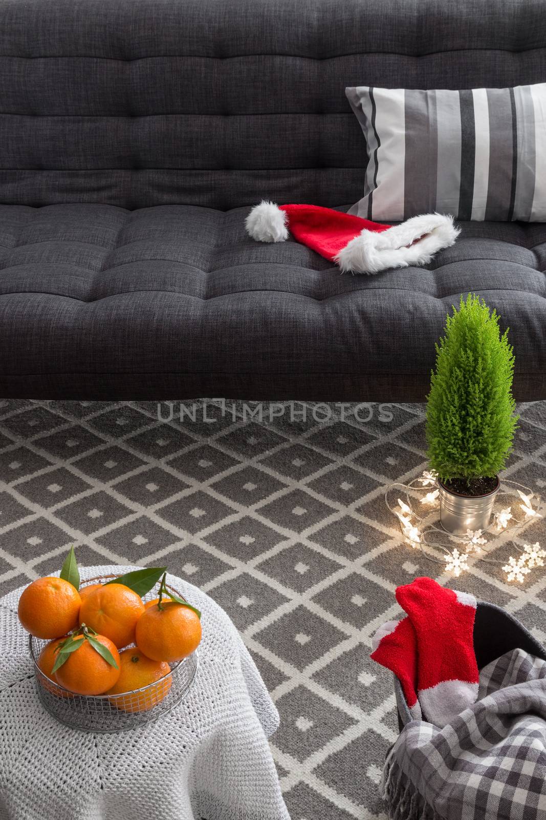 Cozy interior with Christmas decorations and little green tree.