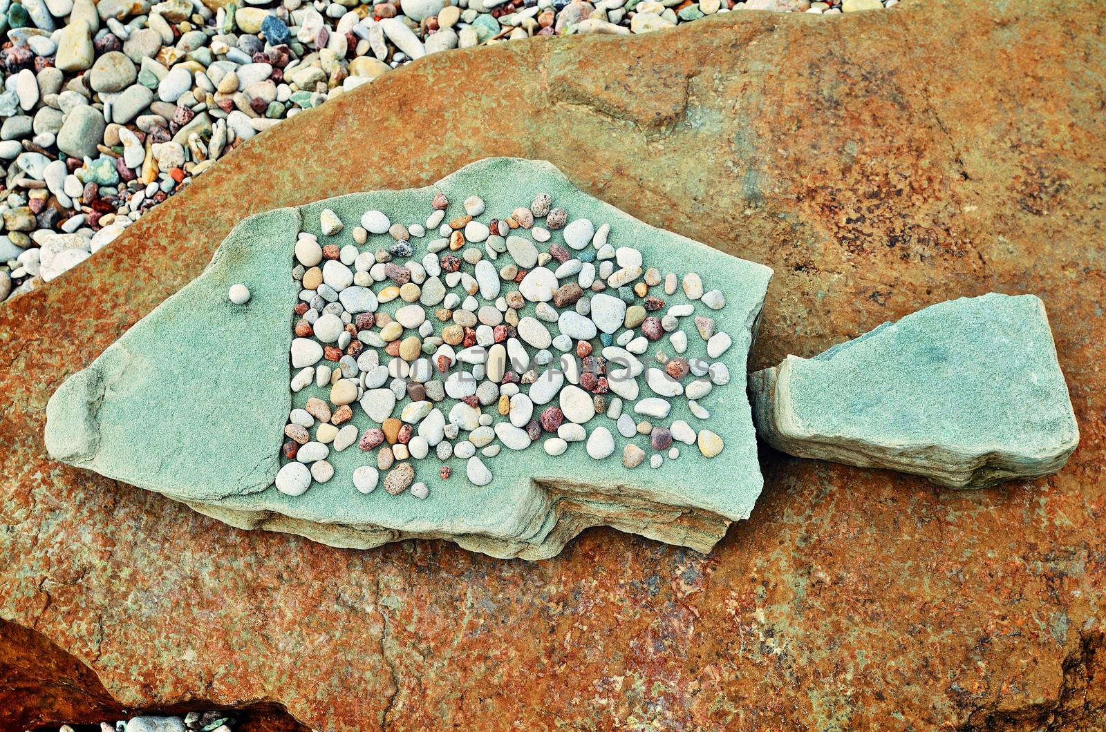 Stone fish of pebbles on the sea boulder